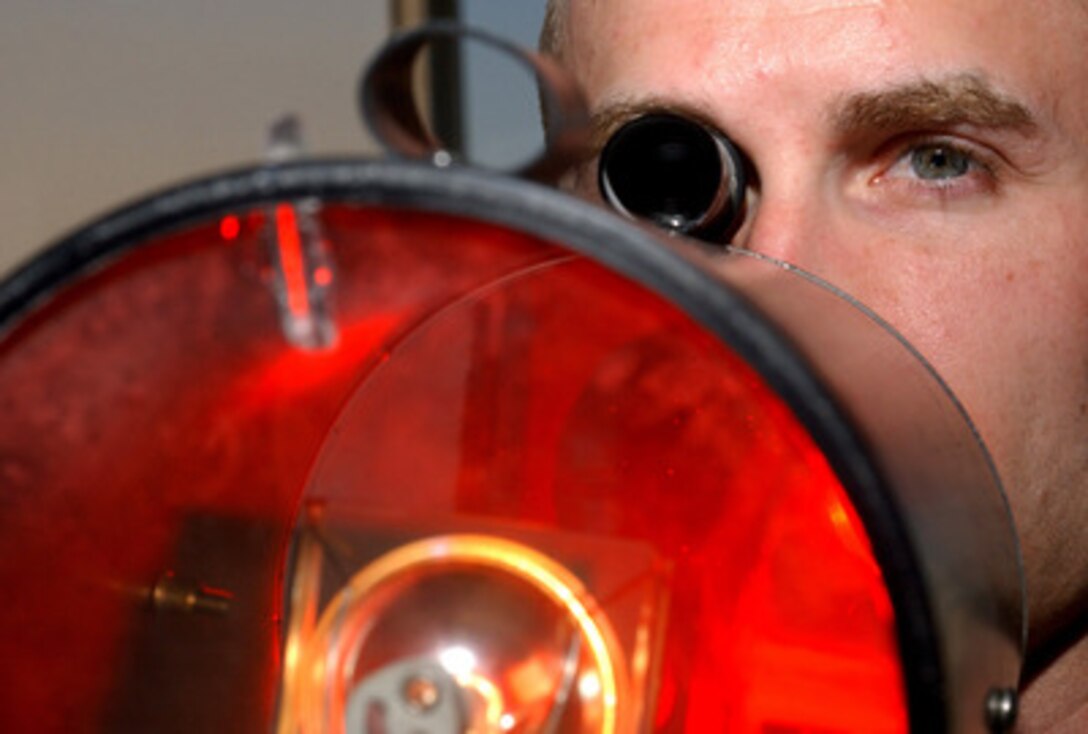 Senior Airman Adam Smith aims a light gun as he works in the control tower at Ali Base, Iraq, on March 8, 2006. The light gun is used to communicate with pilots of aircraft and drivers of vehicles when all radio communications are down. Smith is an air traffic controller with the U.S. Air Force's 407th Expeditionary Operations Support Squadron. 