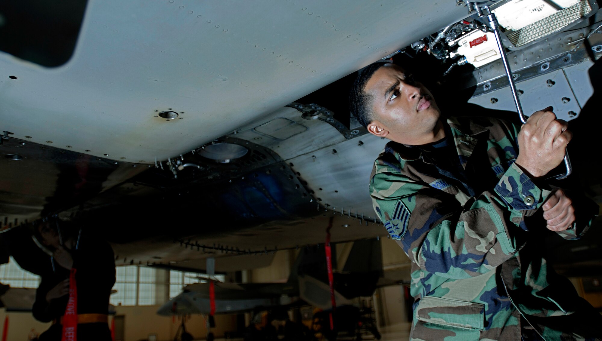Staff Sgt. Sergio Romano tightens the rivets on an F-15 Eagle Tuesday, March 14, 2006, at Langley Air Force Base, Va.  Sergeant Romano is with the 71st Aircraft Maintenance Unit. (U.S. Air Force photo/Airman First Class Christopher Ingersoll) 

 
