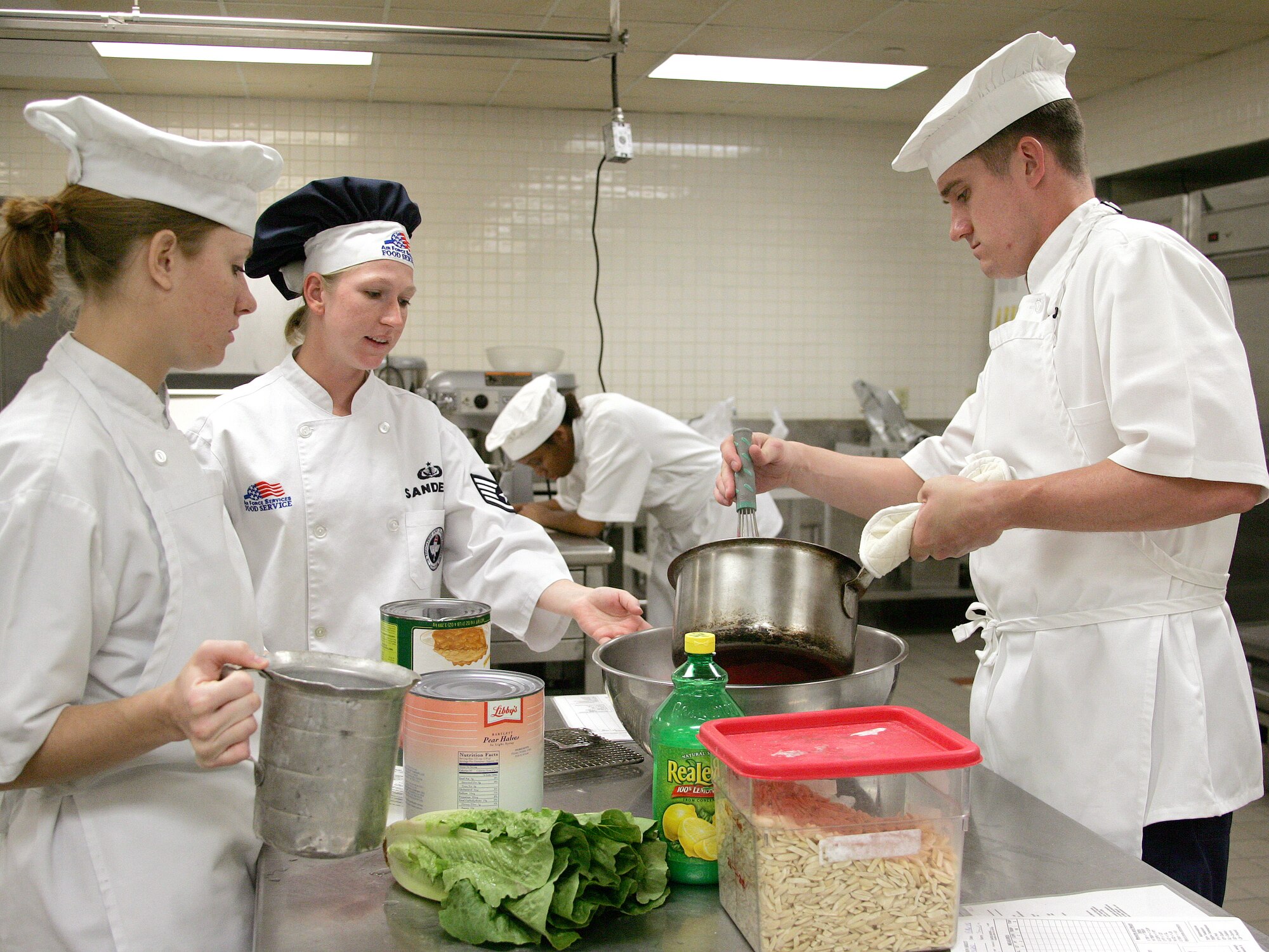 Staff Sgt. Felicia Sanders assists her students as they learn to prepare desserts at the Culinary Arts Training Center, Monday, March 13, 2006. Sergeant Sanders is a services instructor with the 344th Training Squadron at Lackland Air Force Base, Texas.  (U.S. Air Force photo/Robbin Cresswell)                            
