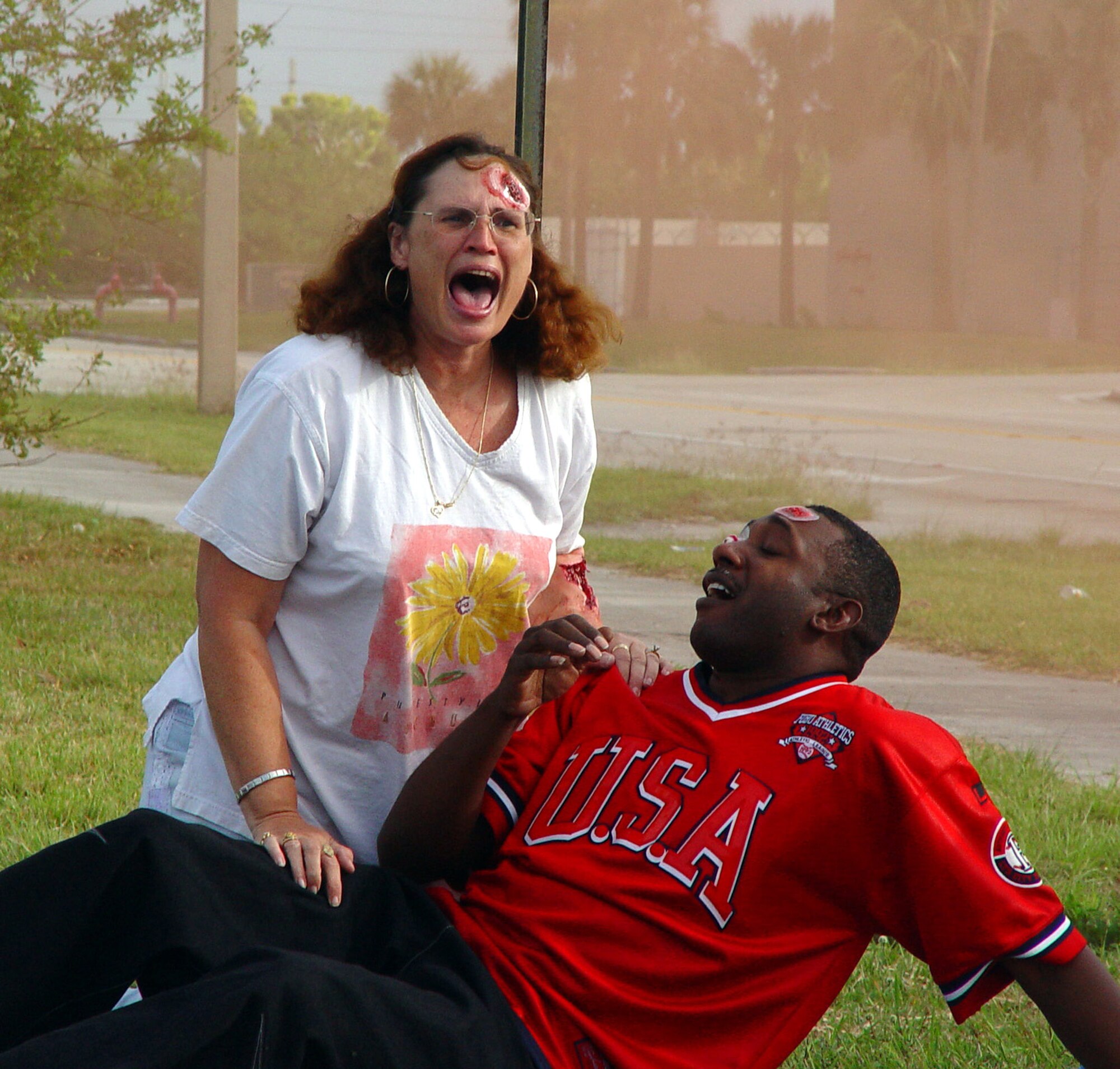 Deana Jacobs and Master Sgt. Frederick Dawson act as injured bystanders during a mass casualty exercise at Homestead Air Reserve Base, Fla. on March 14.  The exercise scenario involved a suicide car bombing just outside the main entrance to the base (U.S. Air Force Reserve photo by Lisa Macias).    