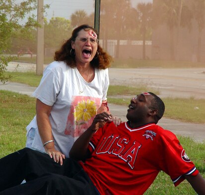 Deana Jacobs and Master Sgt. Frederick Dawson act as injured bystanders during a mass casualty exercise at Homestead Air Reserve Base, Fla. on March 14.  The exercise scenario involved a suicide car bombing just outside the main entrance to the base (U.S. Air Force Reserve photo by Lisa Macias).    