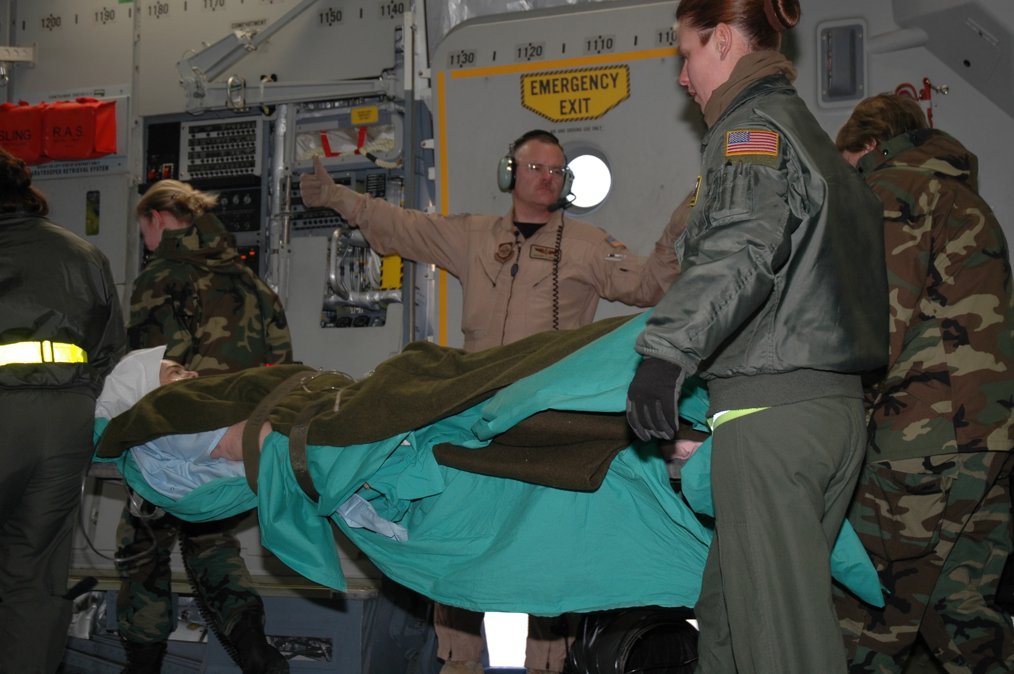 Major Gerard Hogan (center), a reservist assigned to the 315th Aeromedical Evacuation Squadron, Charleston AFB, S.C., directs the movement of a wounded soldier being transferred from Iraq to Germany aboard a C-17 Globemaster III.  (Photo by 1st Lt. Wayne Capps, USAFR)
