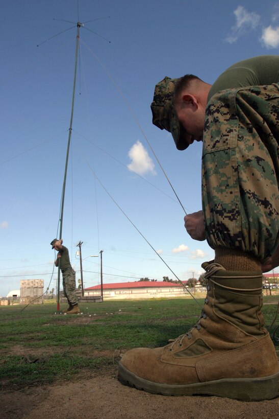 CAMP PENDLETON, Calif. (Mar. 15, 2006) -- Lance Cpl. Carlos M. Forero braces an omni-directional antenna while Lance Cpl. Mercer D. Parrish ties it to a stake here at Camp Del Mar. The communications section of the 15th MEU recently practiced setting up communication equipment in preparation for future training exercises and deployment later this year.