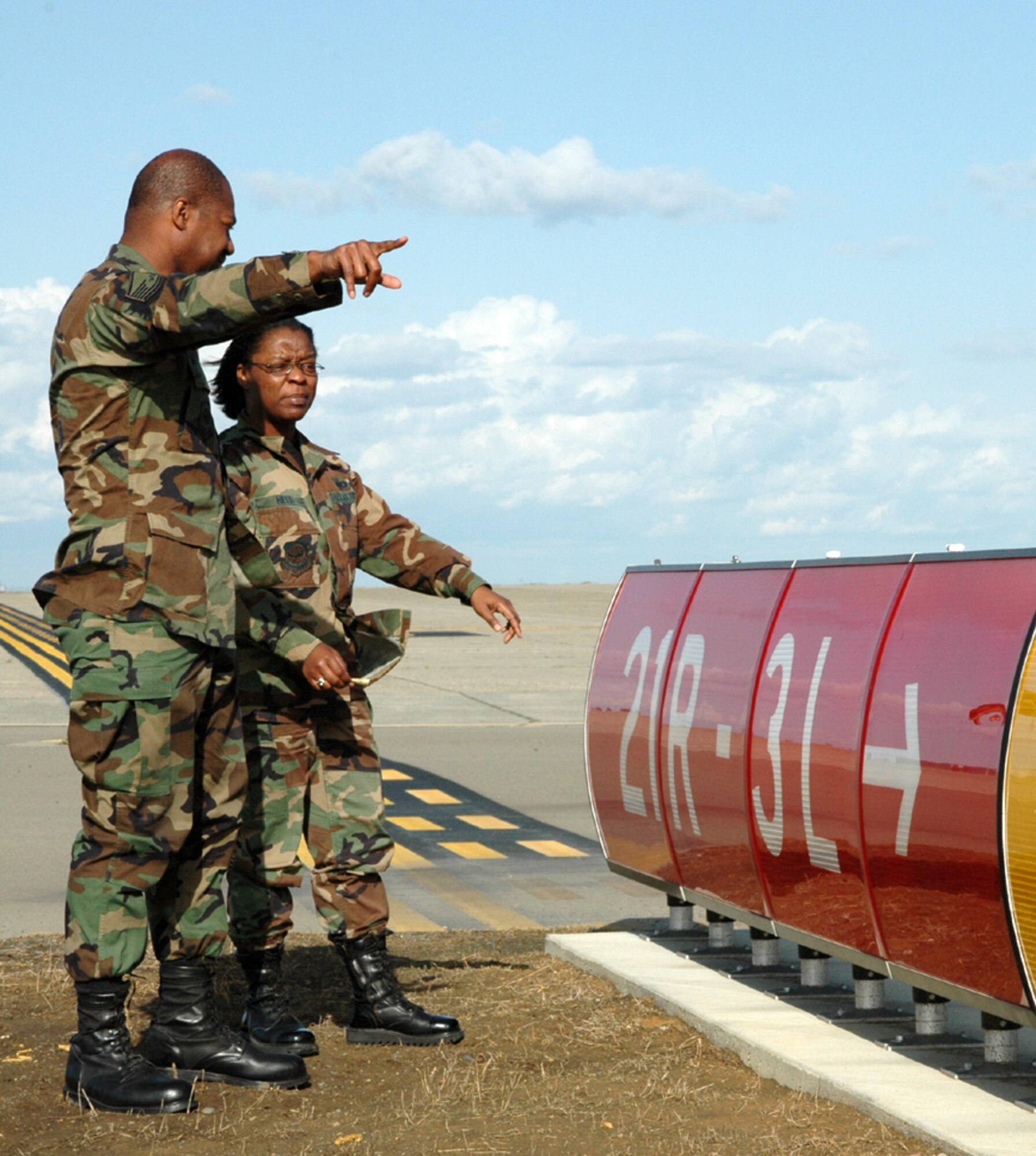 Master Sgt. Wayne Perry, of airfield management, inspects a sign with Master Sgt. Sandra Hess, an inspector from AMC.  The team inspects everything from airfield signs to radios. (U.S. Air Force photo by Staff Sgt. Raymond Hoy)