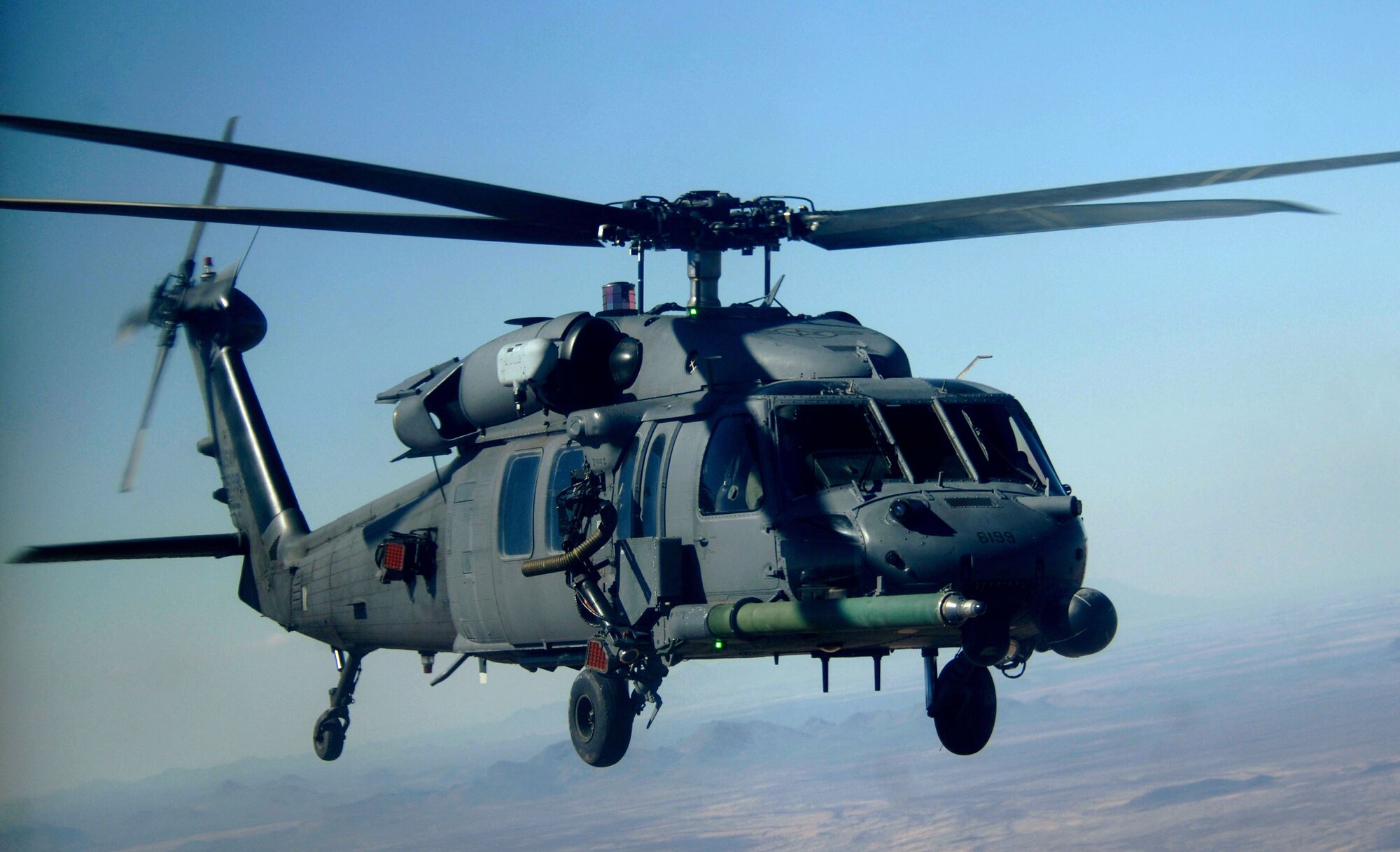 A HH-60 Pavehawk carrying pararescuemen from the 48th Rescue Squadron, flies over a local training area near Davis-Monthan Air Force Base, Ariz., Monday, March 13, 2006. The 55th Rescue Squadron and pararescuemen assigned to the 48th Rescue Squadron, were conducting alternate insertion/extraction training. (U.S Air Force photo/Senior Airman Christina Ponte)