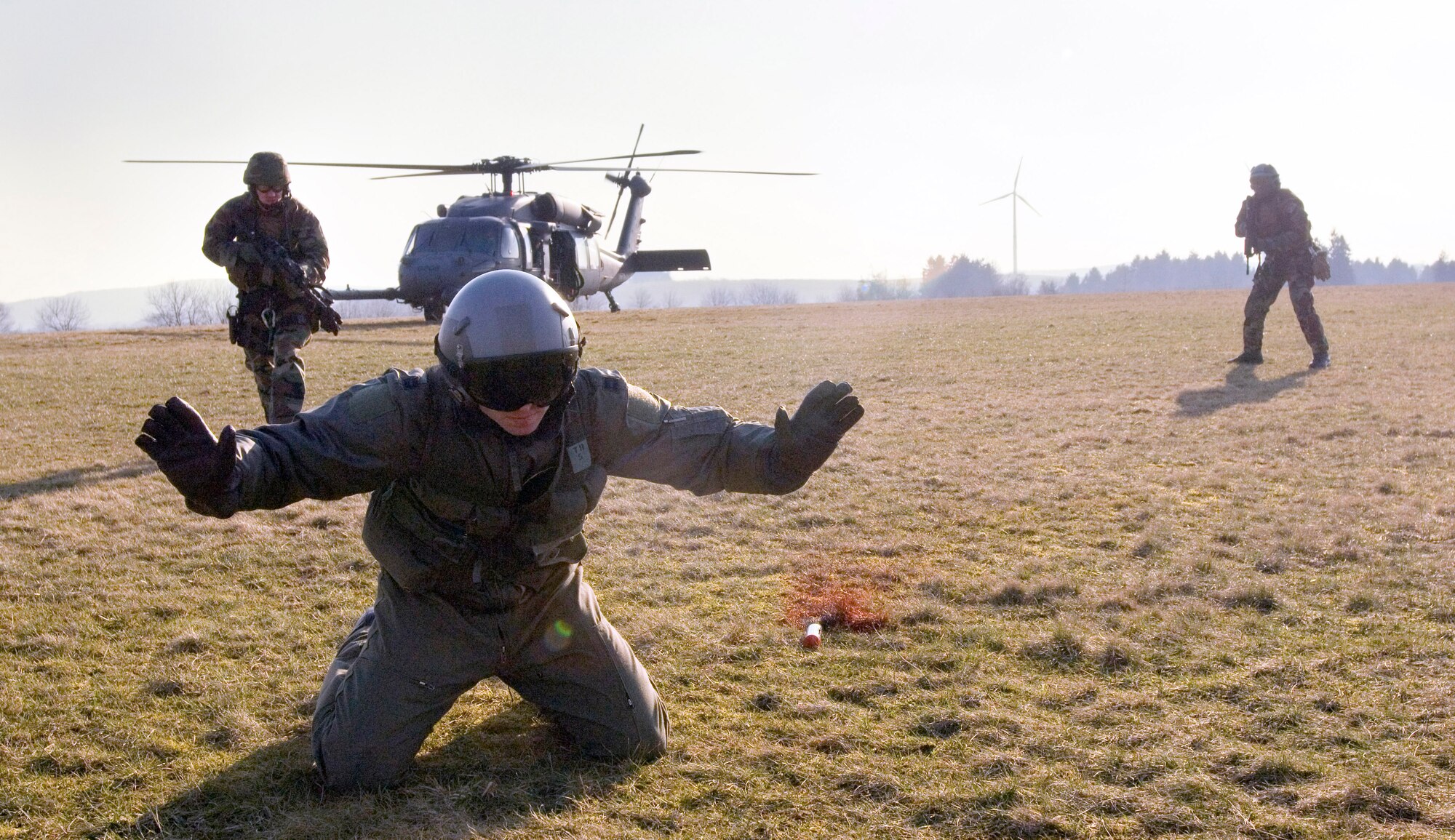 During combat search and rescue training Capt. Doug Galloway waits to be rescued as pararescuemen approach with caution before authenticating and extracting the pilot in an HH-60 Pave Hawk in Marpingen Germany, Monday, March 13, 2006.  The 81st Fighter Squadron from Spangdahlem Air Base, Germany and the 56th Rescue Squadron from Naval Air Station, Keflavik, Iceland trained together here.  Captain Galloway is an A-10 fighter pilot from Fort Walton Beach, Fla., with the 81st Fighter Squadron at Spangdahlem Air Base, Germany.   (U.S. Air Force photo/Master Sgt. John Lasky)