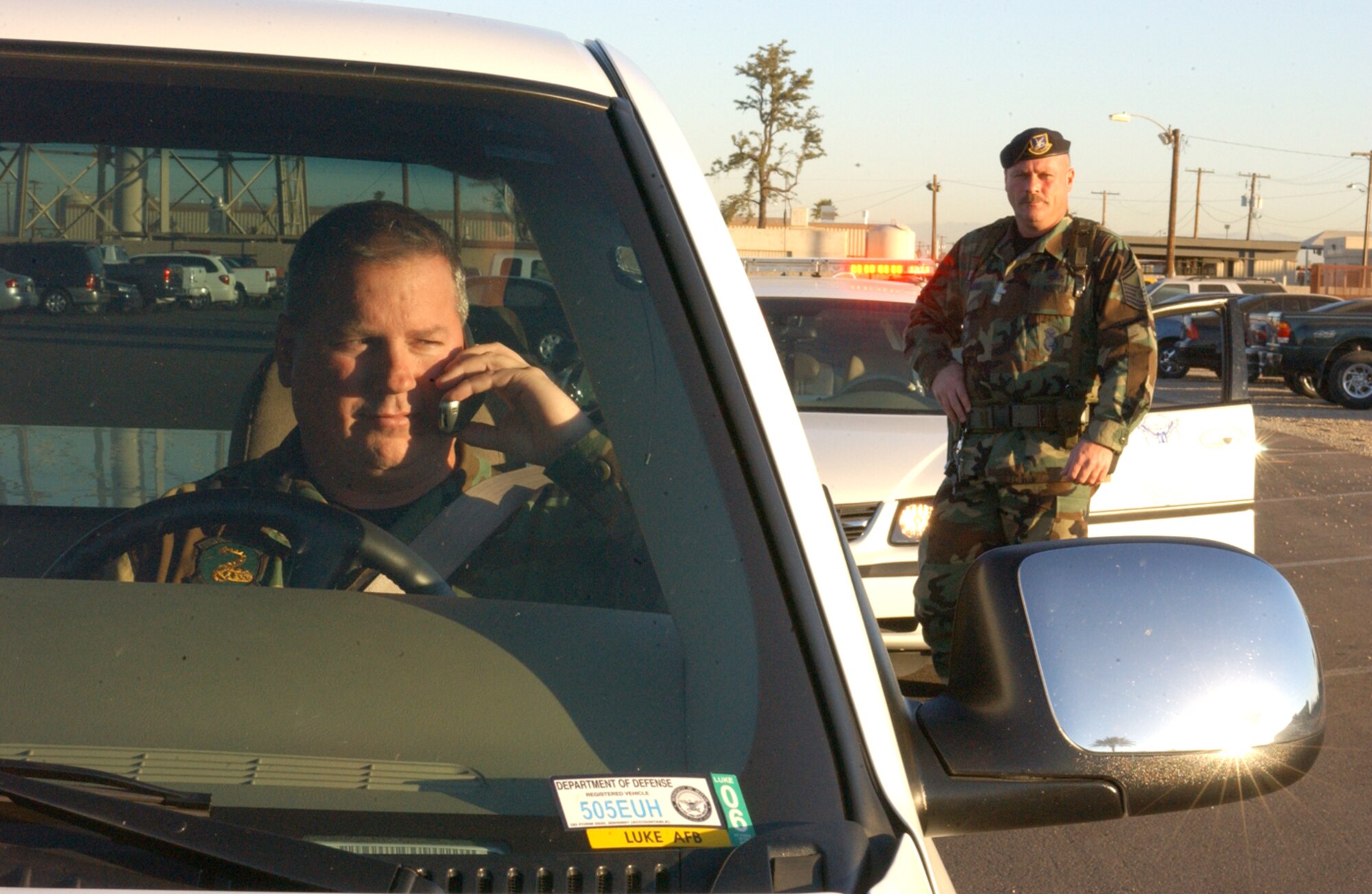Master Sgt. Curtis Cooper, 56th Security Forces Squadron, simulates a traffic stop with Tech. Sgt. Richard Madget, 56th SFS. Defenders will issue warnings to drivers on cell phones for a 30-day grace period, then will begin issuing citations. (U.S. Air Force photo by Senior Airman Joseph Thompson)                             