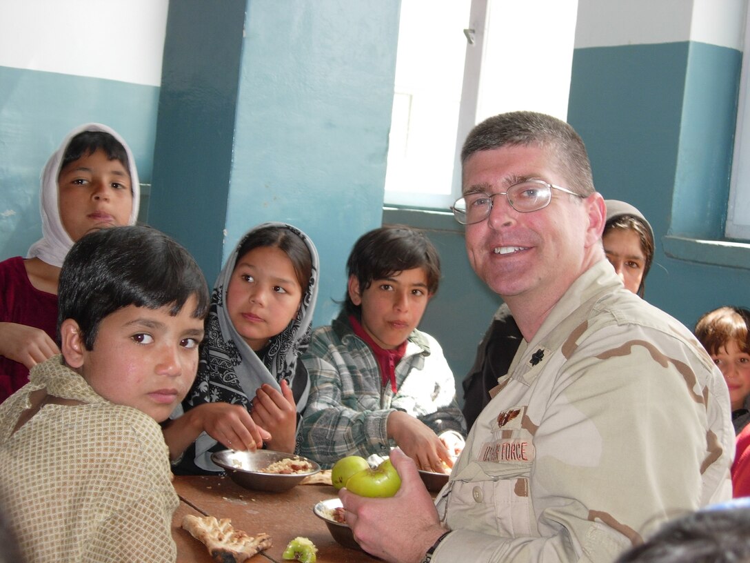 Lt. Col. Scott Owens, Special Projects Squadron commander, eats with some children at an orphanage during his deployment to Afghanistan in 2005. Recently he was named the 2005 Air Force Outstanding Military Acquisition Staff Officer for his accomplishments in support of Operation Enduring Freedom. (Courtesy photo)