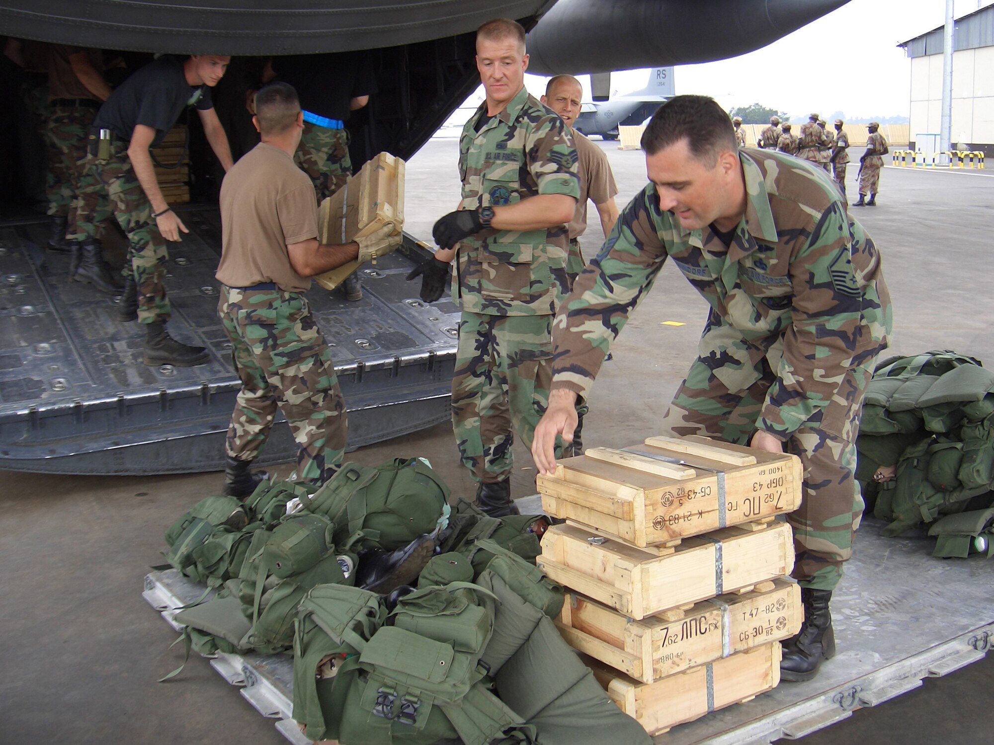 KIGALI, Rwanda (USAFENS) -- Senior Airman David O'Leary, 86th Air Mobility Squadron (left), and Master Sgt. Scott Windsor, 37th Airlift Squadron, load equipment for the Rwandan peacekeepers that departed here Sept. 30.  Upon request by NATO, U.S. European Command tasked the more than 150 Airmen from Ramstein Air Base, Germany, to set up operations here in support of the African Union's airlift mission. (Photo by 1st Lt. Elizabeth Culbertson)