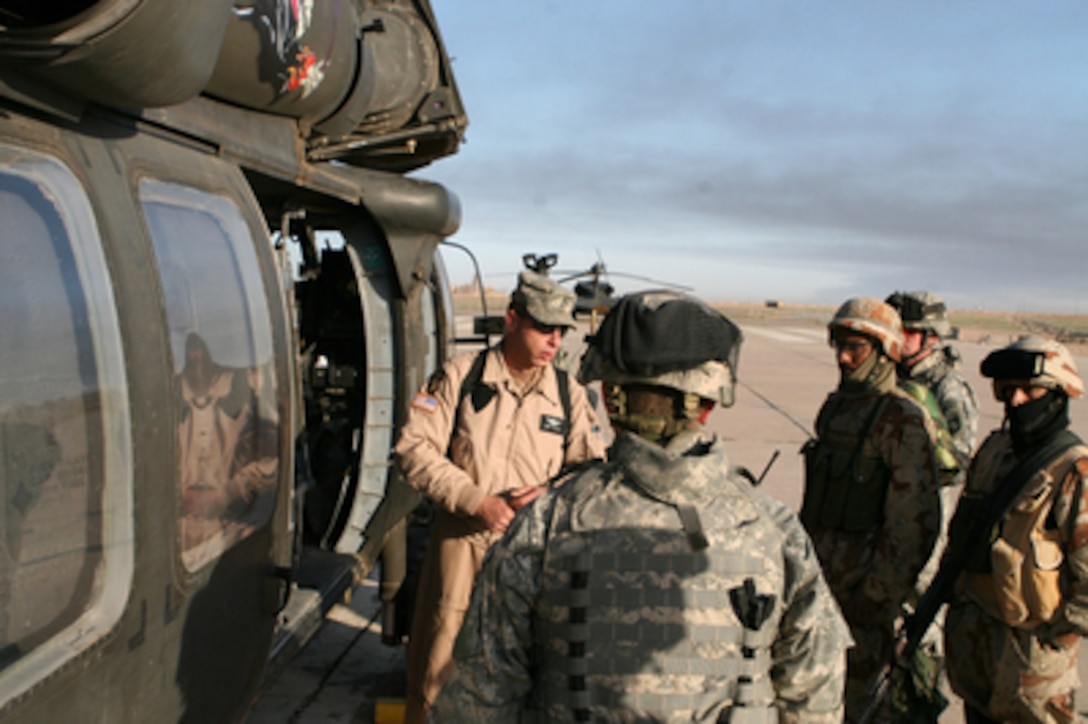 Soldiers from the Iraqi Army's 1st Brigade, 4th Division and the U.S. Army's 101st Airborne Division's 3rd Brigade Combat Team receive a pre-flight briefing from a UH-60 Black Hawk crew chief at Forward Operating Base Remagen, Iraq, prior to the start of Operation Swarmer on March 16, 2006. Operation Swarmer is a combined air assault operation to clear the area northeast of Samarra of suspected insurgents. 