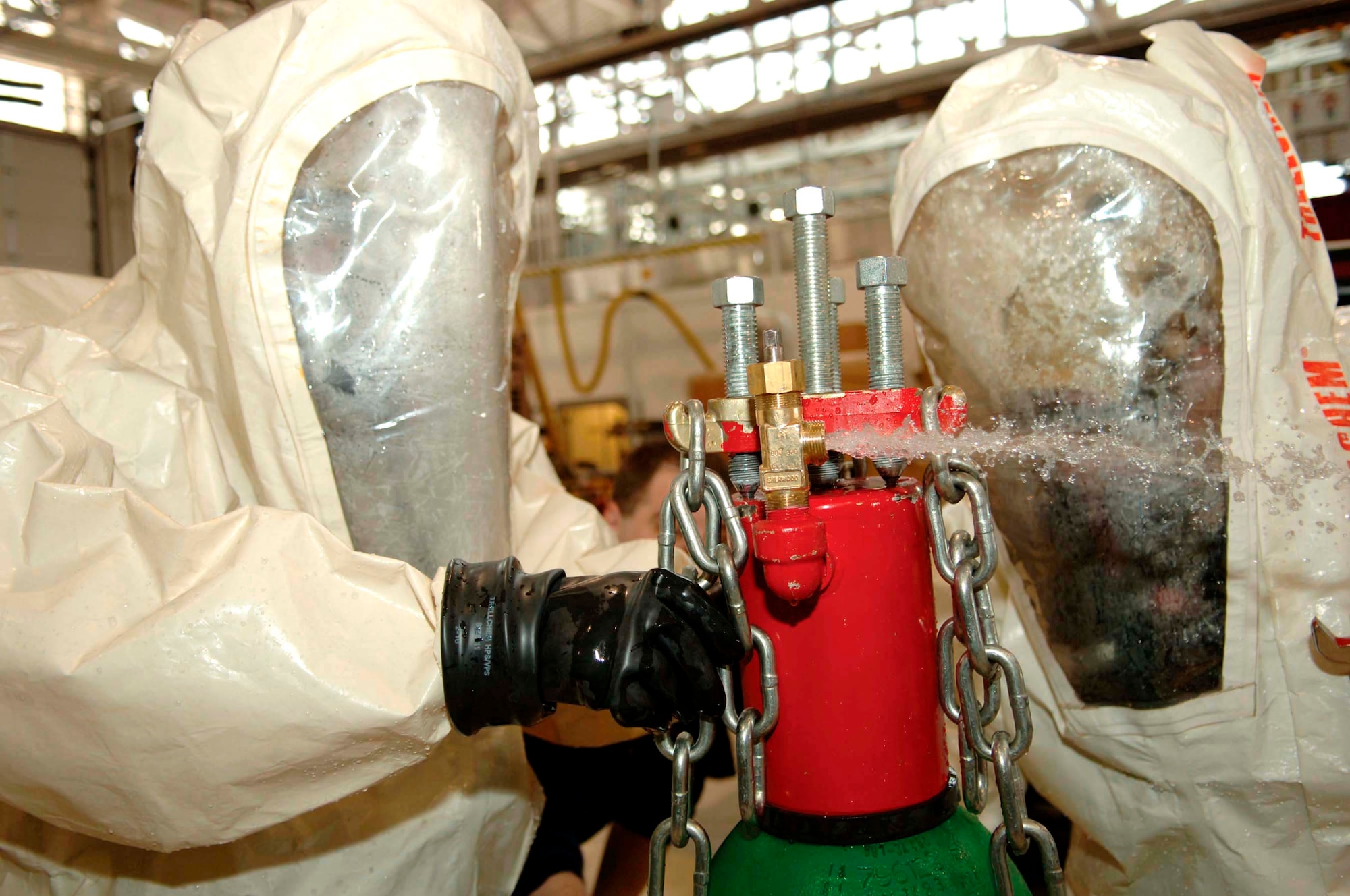 Airman 1st Class Seth Maher (left) and Tech. Sgt. Michael Hall, both 5th Civil Engineering Squadron firefighters, participate in a hazardous material training exercise at Minot Air Force Base Tuesday, March 14, 2006. Airman Maher and Sergeant Hall simulated stopping a chlorine leak on different equipment. (U.S. Air Force photo/Senior Airman Stacy Moless)