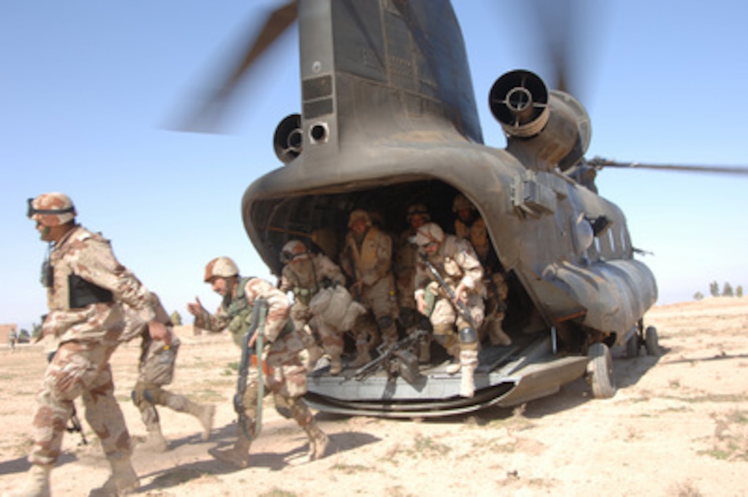 Iraqi and U.S. Army soldiers exit a U.S. Army CH-47 Chinook helicopter during Operation Swarmer in Iraq on March 16, 2006. Soldiers from the Iraqi Army's 1st Brigade, 4th Division and the U.S. Army are taking part in the combined air assault operation to clear the area northeast of Samarra of suspected insurgents. 