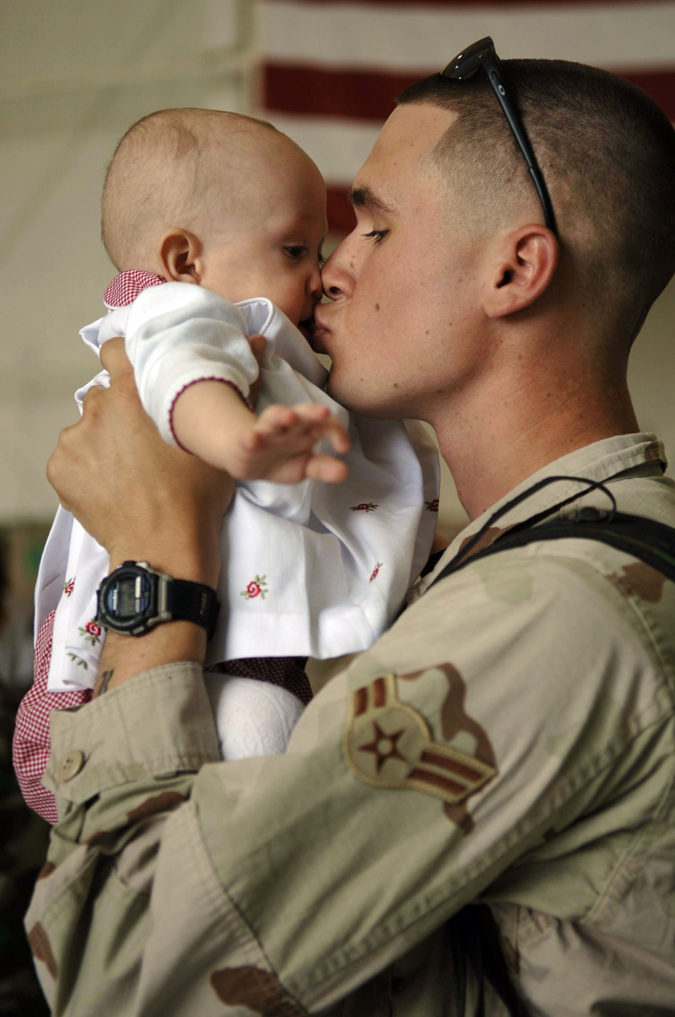 Airman 1st Class Daniel Wurdinger kisses his daughter, De`nae, as he returns to Davis-Monthan Air Force Base, Ariz., from his deployment in support of Operation Iraqi Freedom, Friday, March 17, 2006. Airman Wurdinger is with the 355th Security Forces Squadron.  (U.S. Air Force photo/Senior Airman Christina D. Ponte)