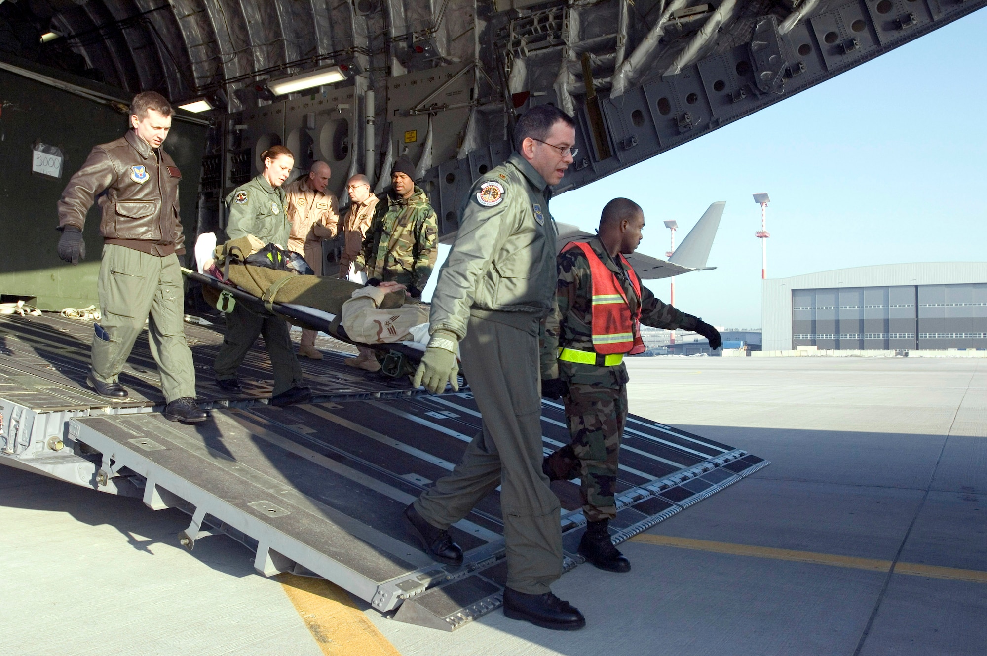 Maj. Mark McDaniel, Tech. Sgt. Misti Adams, Maj. Dale Grey and Staff Sgt. Dwayne Gulley, left to right, carry a litter from a C-17 Globemaster III at Ramstein Air Base, Germany, on Monday, March 20, 2006. The Mississippi Air National Guard transport flew to Iraq to deliver cargo and returned as an aeromedical evacuation flight. On the return, it surpassed the transport fleet's 1 millionth hour of flight milestone. Majors McDaniel and Grey and Sergeant Gully are with Ramstein's 435th Aerospace Medical Squadron. Sergeant Adams is with the Ramstein's 791st Expeditionary Aeromedical Evacuation Squadron. (U.S. Air Force photo/Master Sgt. John E. Lasky) 