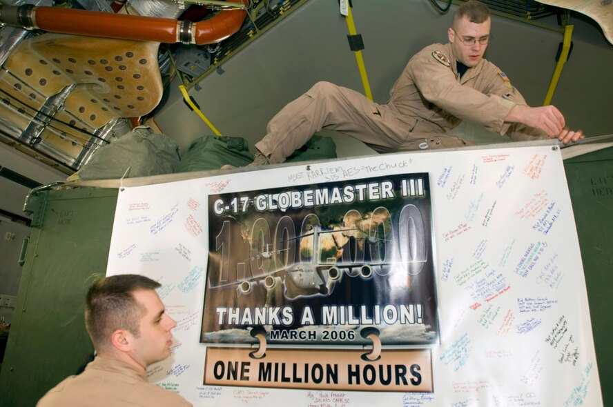 Senior Airmen Christian Adams, above, and Daniel Wood hang a sign inside a C-17 Globemaster III at Ramstein Air Base, Germany, on Sunday, March 19, 2006. The Mississippi Air National Guard transport delivered cargo to Al Asad, Iraq, and returned from Balad Air Base, Iraq, as an aeromedical mission that put the air transport past the 1 millionth hour of flight time. The Airmen are medical technicians on temporary duty to Ramstein's 791st Expeditionary Aeromedical Evacuation Squadron. (U.S. Air Force photo/Master Sgt. John E. Lasky) 