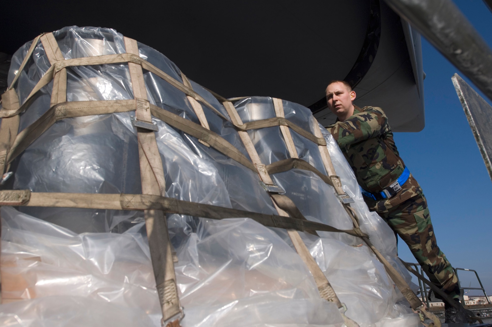 Staff Sgt. Brian Derry pushes a pallet onto a C-17 Globemaster III at Ramstein Air Base, Germany, on Sunday, March 19, 2006. The Mississippi Air National Guard transport was due to fly to Al Asad and Balad Air Base, Iraq, as part of a mission that would put the air transport past the 1 millionth hour of flight time. Sergeant Derry is an air transportation specialist with Ramstein's 723rd Air Mobility Squadron. (U.S. Air Force photo/Master Sgt. John E. Lasky) 

