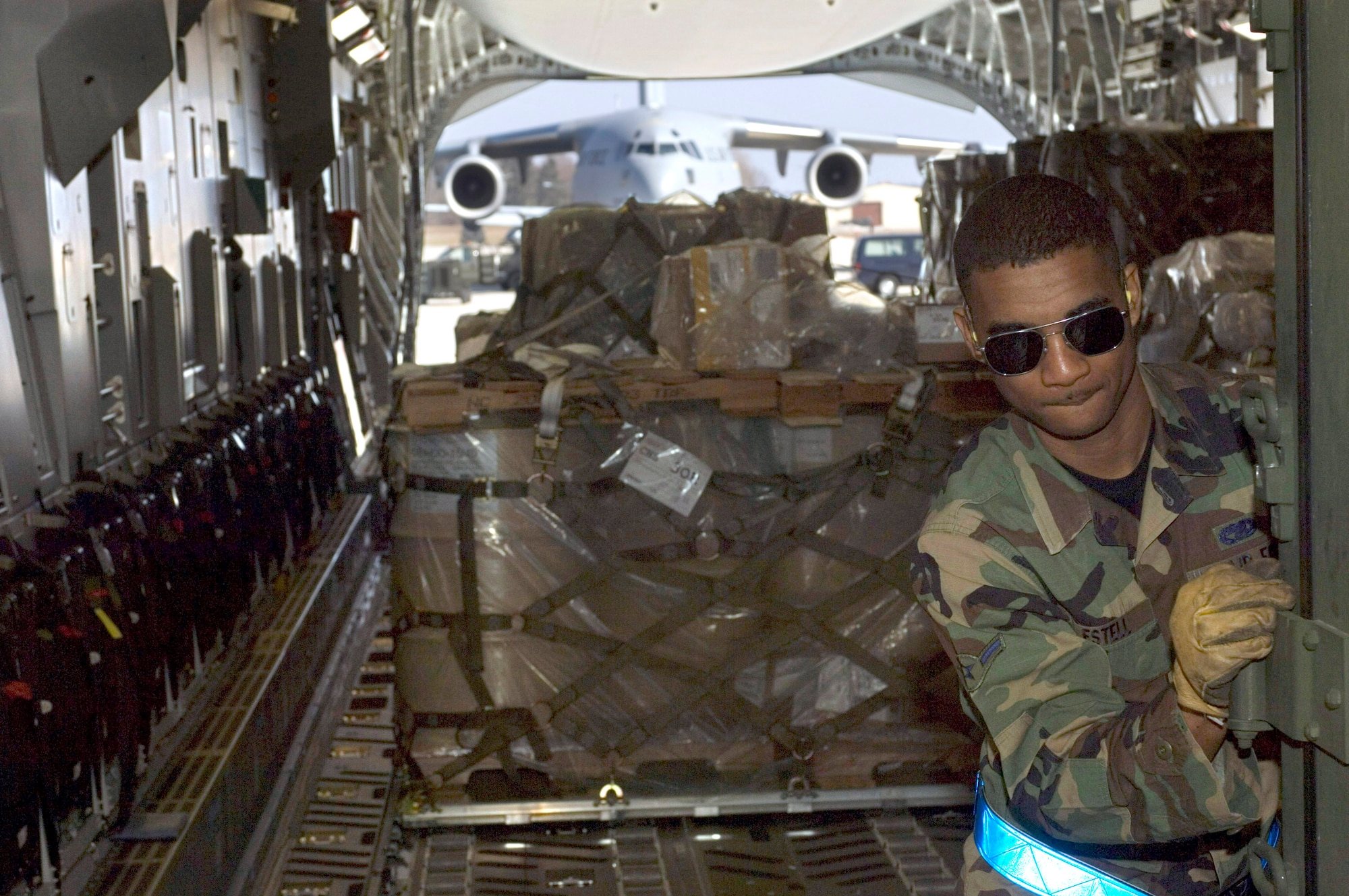 Airman Jason Estell pushes a pallet onto a C-17 Globemaster III at Ramstein Air Base, Germany, on Sunday, March 19, 2006. The Mississippi Air National Guard transport was due to fly to Al Asad and Balad Air Base, Iraq, as part of a mission that would put the air transport past the 1 millionth hour of flight time. Airman Estell is an air transportation specialist with Ramstein's 723rd Air Mobility Squadron. (U.S. Air Force photo/Master Sgt. John E. Lasky) 