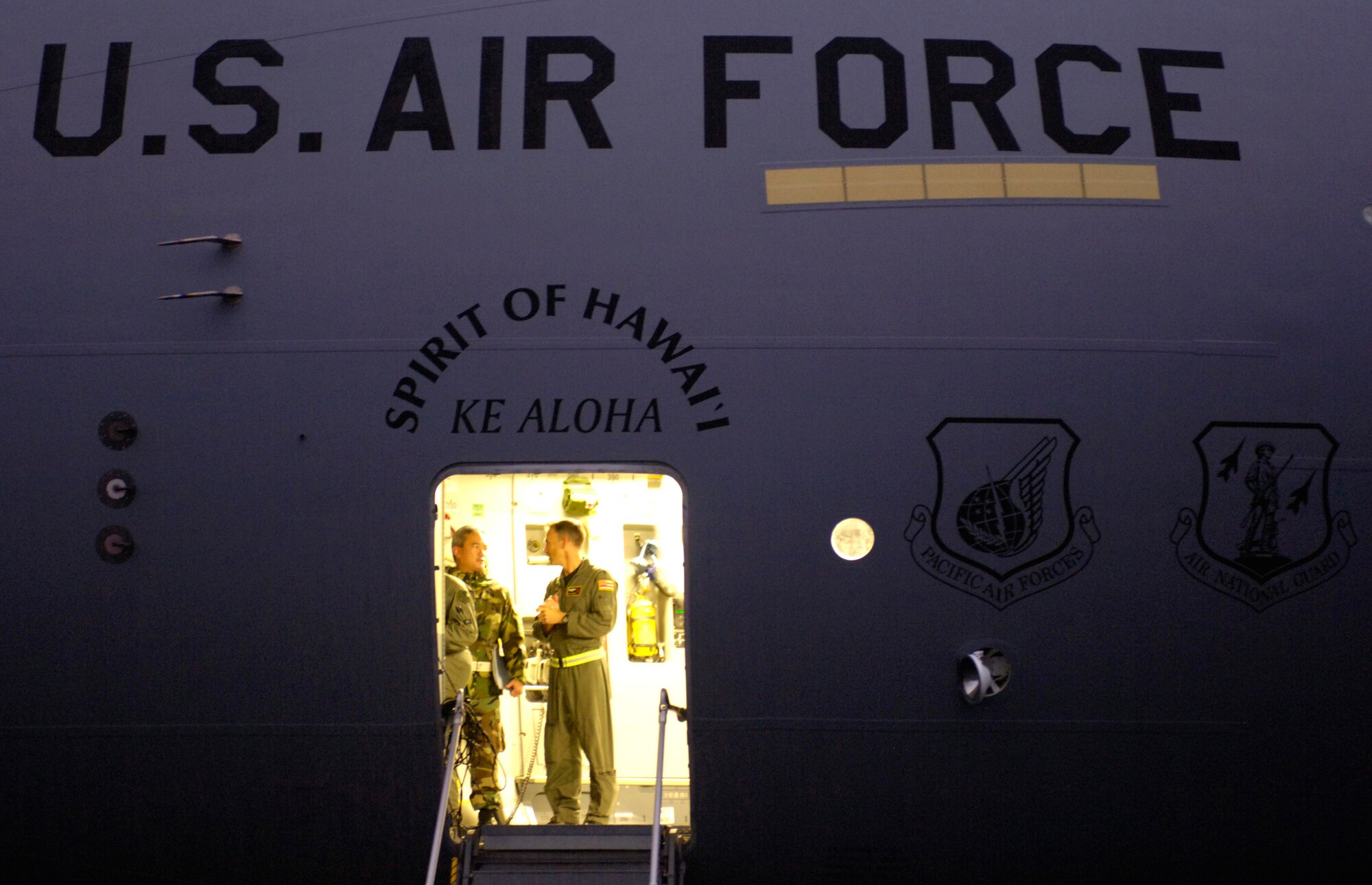 Lt. Col. Woody Woodrow and Master Sgt. Bruce Hara discuss loading recovery equipment on a C-17 Globemaster III at Hilo International Airport, Hawaii, Thursday, March 16, 2006. The C-17 delivered recovery equipment to the island of Kauai, Hawaii after a dam burst, isolating thousands of people along the island's north shore. Colonel Woodrow is with the Hawaii Air National Guard's 204th Airlift Squadron and Sergeant Hara is with Guard's 291st Combat Communication Squadron. (U.S. Air Force photo/Tech. Sgt. Shane A. Cuomo) 