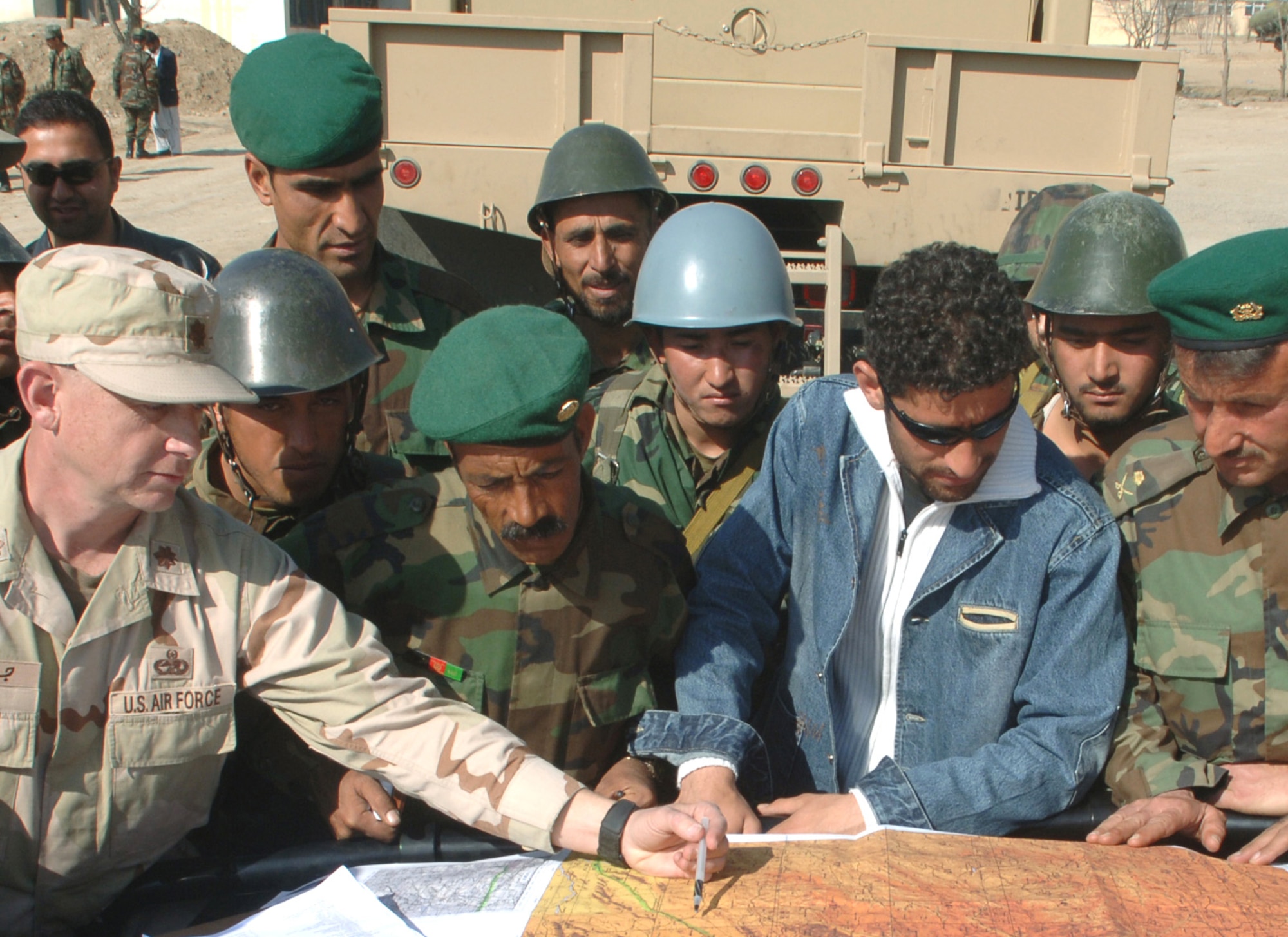 Maj. Richard Jones II (left) briefs soldiers from the Afghan National Army's Central Management Agency on the route they will take for their first long-haul convoy mission on Sunday, March 12, 2006, in Kabul, Afghanistan. Major Jones is the senior mentor assigned to the 755th Expeditionary Mission Support Group's CMA embedded training team. (U.S. Air Force photo/Staff Sgt. Jennifer Redente) 