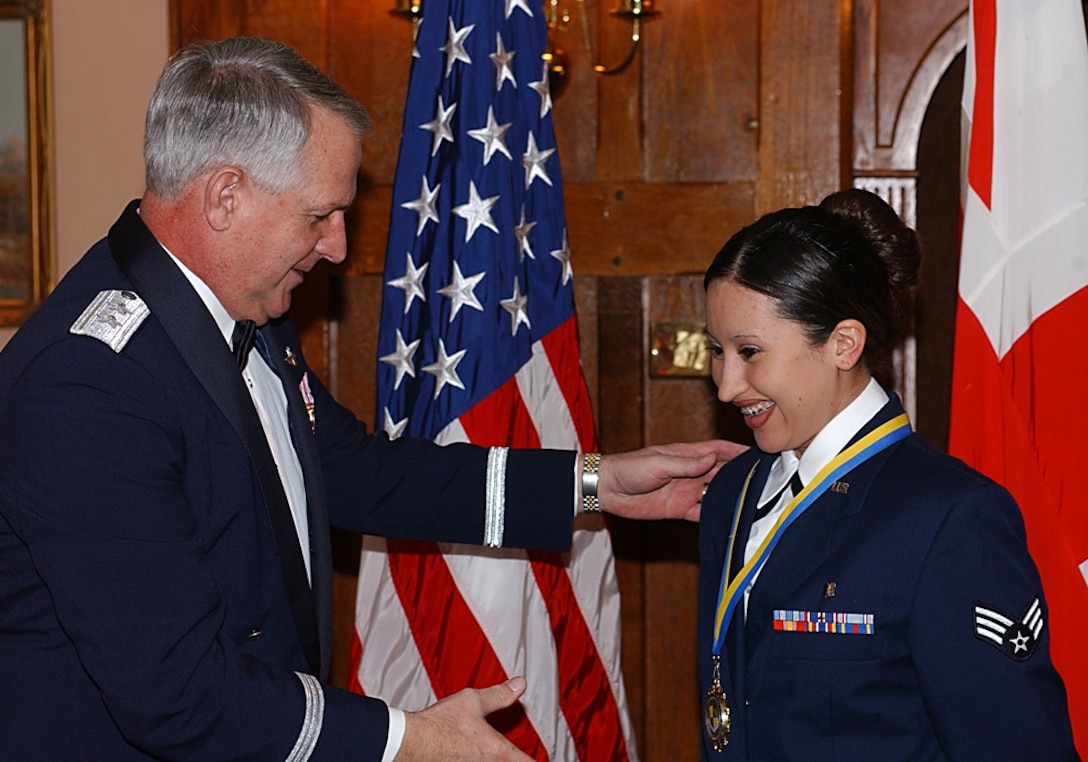 ROYAL AIR FORCE ALCONBURY, England – Maj. Gen. Paul Fletcher, 16th Air Force vice commander, congratulates Senior Airman Cynthia Atilano, 423rd Air Base Squadron dental technician, as a nominee for the 501st Combat Support Wing Airman of the Year during a medallion ceremony here Feb. 24.