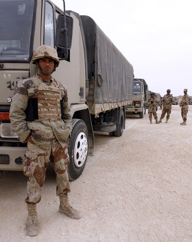 An Iraqi soldier stands by his truck as he waits to go on a practice convoy at Al Asad Air Base, March 20, 2006. More than 120 soldiers from the Iraqi 8th Motor Transport Regiment are getting region-specific and refresher training from Marines here to prepare them for convoy operations in the dangerous Al Anbar Province. Motor transportation specialists with the Marines' Combat Logistics Battalion - 7 are training their Iraqi counterparts how to move troops and supplies throughout Iraq while facing improvised explosive devices, enemy ambushes and rough roads.