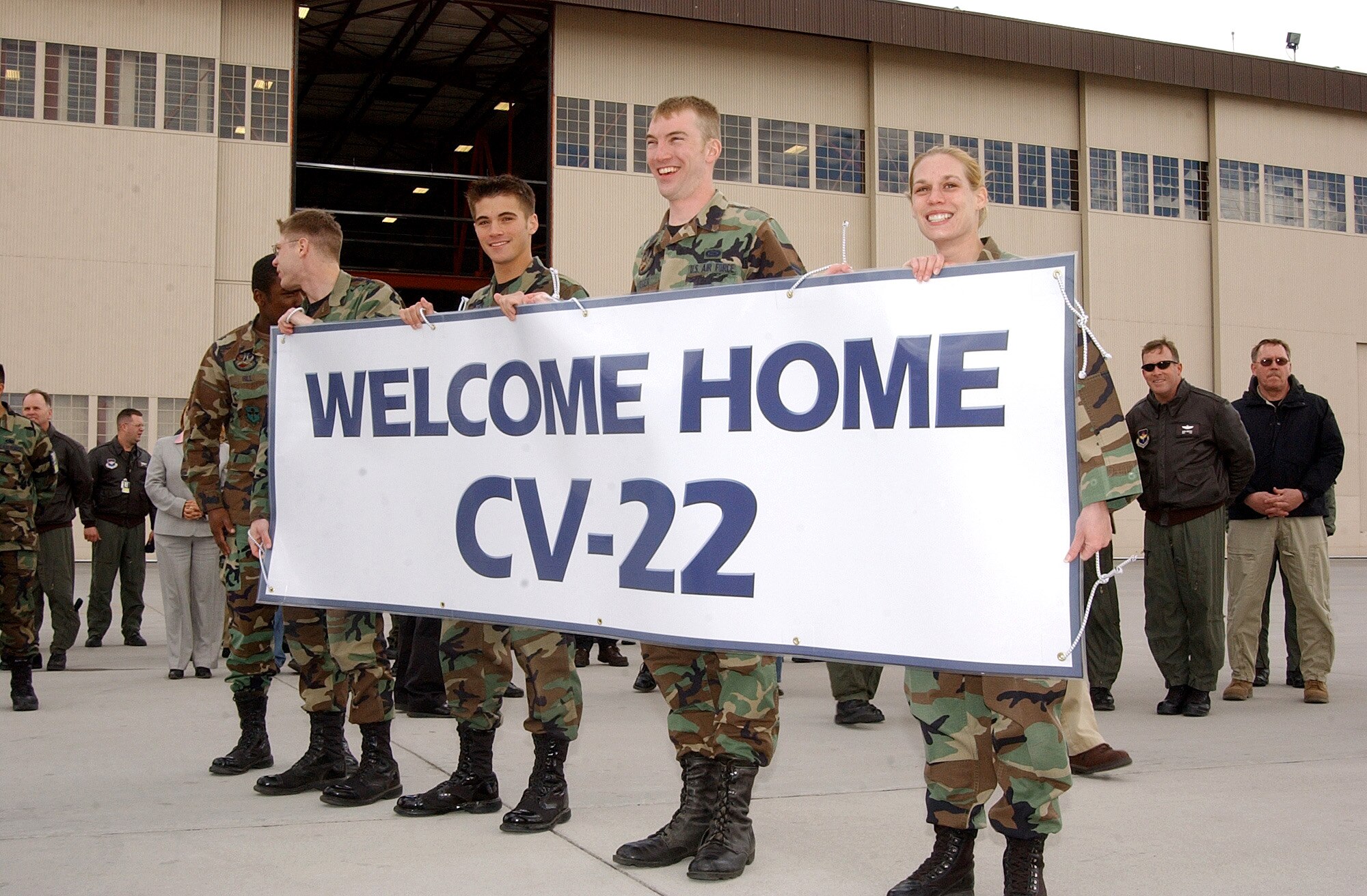 Airmen with the 58th Special Operations Wing hold a banner welcoming the Air Force's first operational CV-22 Osprey to Kirtland AFB, N.M., Monday, March 20, 2006.  The aircraft was flown to Kirtland by Lt. Gen. Michael W. Wooley, commander of Air Force Special Operations Command. (U.S. Air Force photo/Staff Sgt. Markus Maier)

