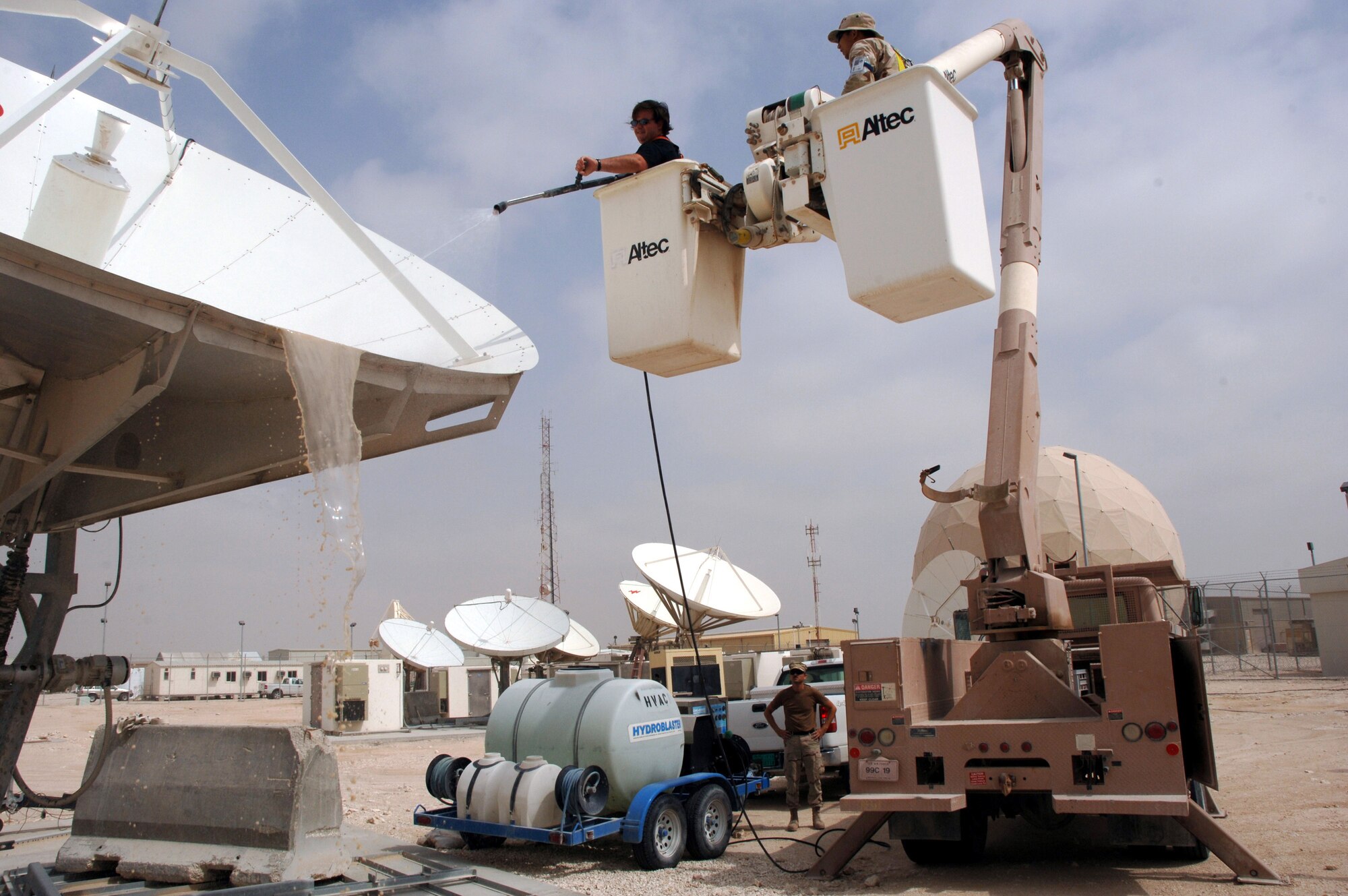 Matt Rogers power-washes satellite dishes at a deployed location in Southwest Asia on Sunday, March 19, 2006, with a lift from the 379th Expeditionary Civil Engineer Squadron. The satellites provide communication capabilities to forward-deployed units. Mr. Rogers is a civilian contractor. (U.S. Air Force photo/Staff Sgt. Joshua Strang)