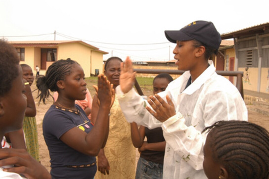 U.S. Navy Petty Officer 3rd Class Melanie Williams plays a game with a student during a break from painting at the Matanda Elementary School in Port Gentil, Gabon, on March 16, 2006. Williams, a Navy hospital corpsman, and her fellow crewmembers of the submarine tender USS Emory S. Land (AS 39) are conducting a community relations project at the school. 
