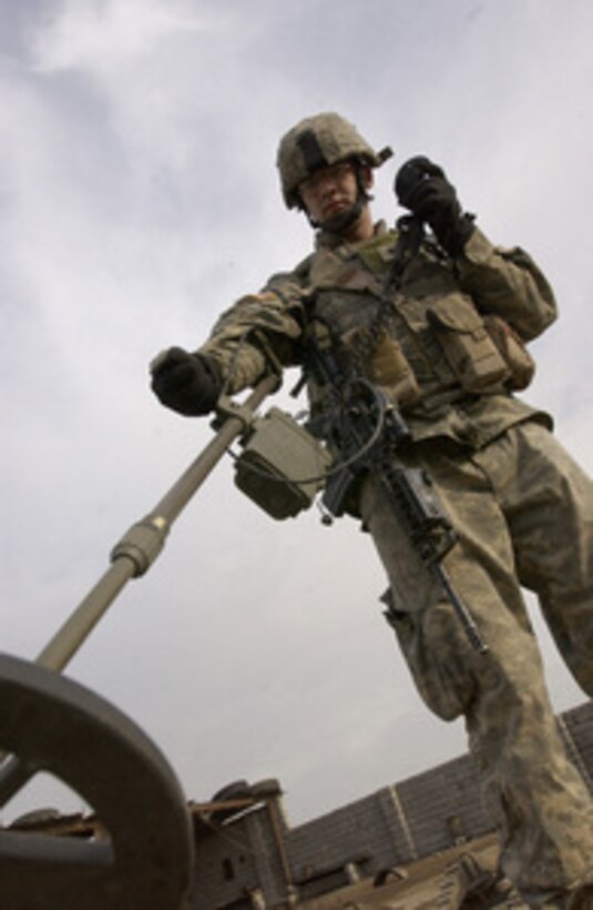 Army Spc. Joe Browning uses a metal detector to search for buried weapons caches and materials used to make improvised explosive devices during a neighborhood patrol in Mosul, Iraq, on March 18, 2006. Browning is attached to the 2nd Battalion, 1st Infantry Regiment, 172nd Infantry Brigade. 