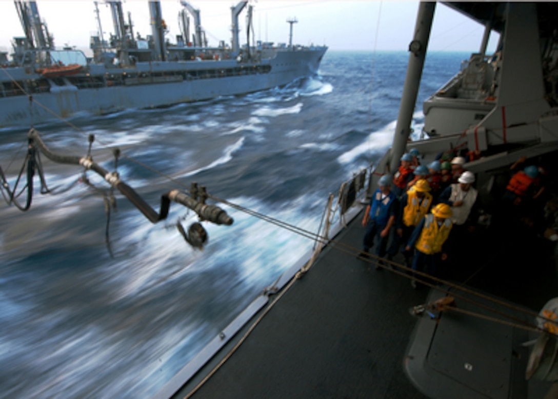 Sailors aboard the amphibious command ship USS Blue Ridge (LCC 19) watch as a refueling probe crosses over from the USNS Walter S. Diehl (T-AO 193) during a replenishment at sea in the South China Sea on March 19, 2006. The Blue Ridge is taking on fuel and stores from the underway replenishment oiler Diehl as the two ships steam in formation. 