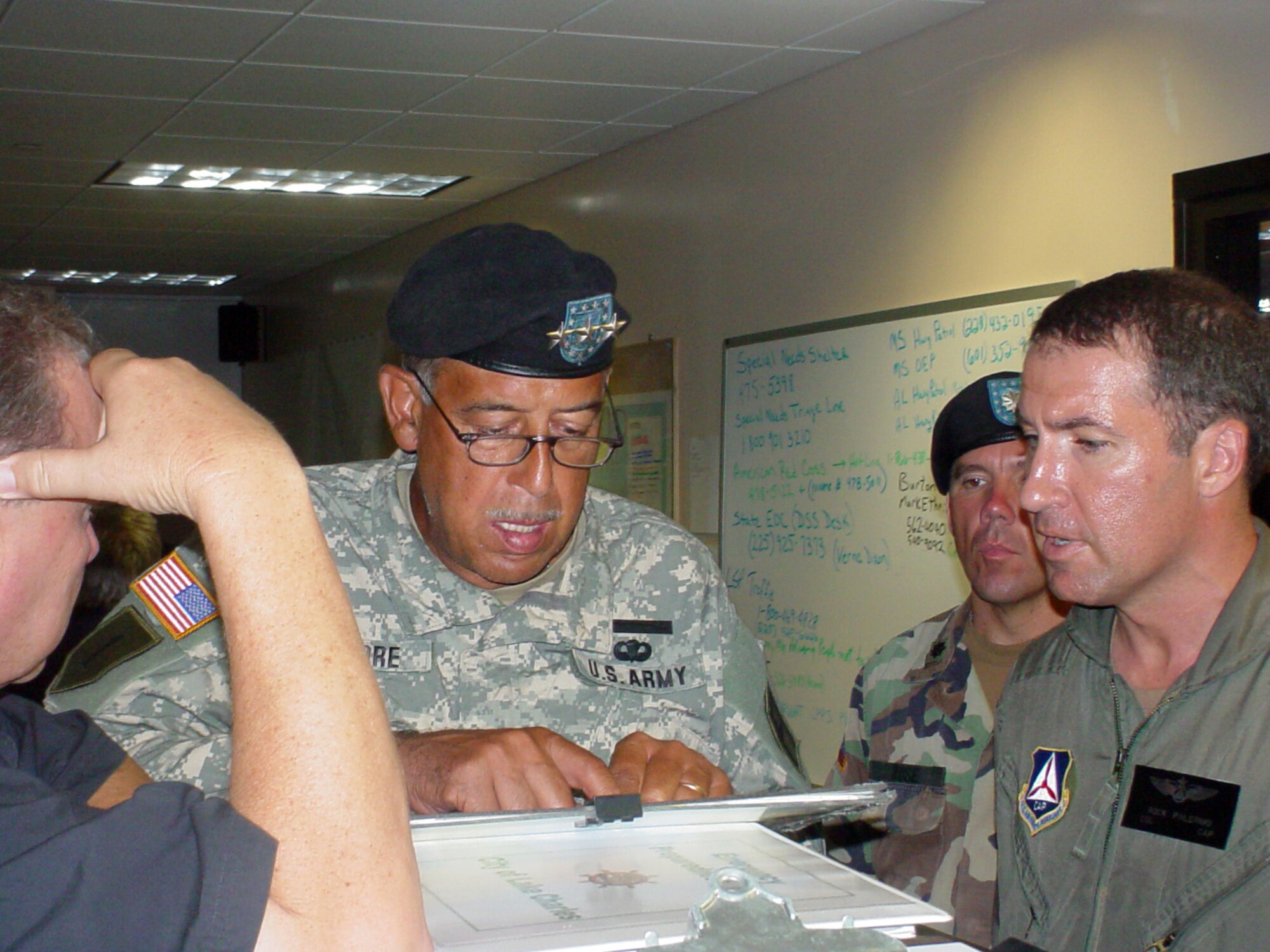 Dick Gremillion, Army Lt. Gen. Russel L. Honori and Civil Air Patrol Col. Rock Palermo discuss hurricane relief efforts at the operations center in Lake Charles, La. After Hurricane Rita, Colonel Palermo spent nearly three weeks directing local emergency operations in his hometown of Lake Charles. He was drafted as operations section chief and later deputy director because of his past disaster management experience. (U.S. Air Force photo/Tom R. Malmay Jr.) 