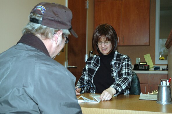 YOUNGSTOWN AIR RESERVE STATION, Ohio - Darlene Hewitt, a Security Assistant with the 910th Security Forces Squadron here, assists retired Navy Petty Officer Jay Enger with his vehicle registration.  Mr. Enger is just one of the more than 3,000 people that use the Visitor Center annually to obtain access to the base. (U.S. Air Force photo/MSgt. Bryan Ripple)