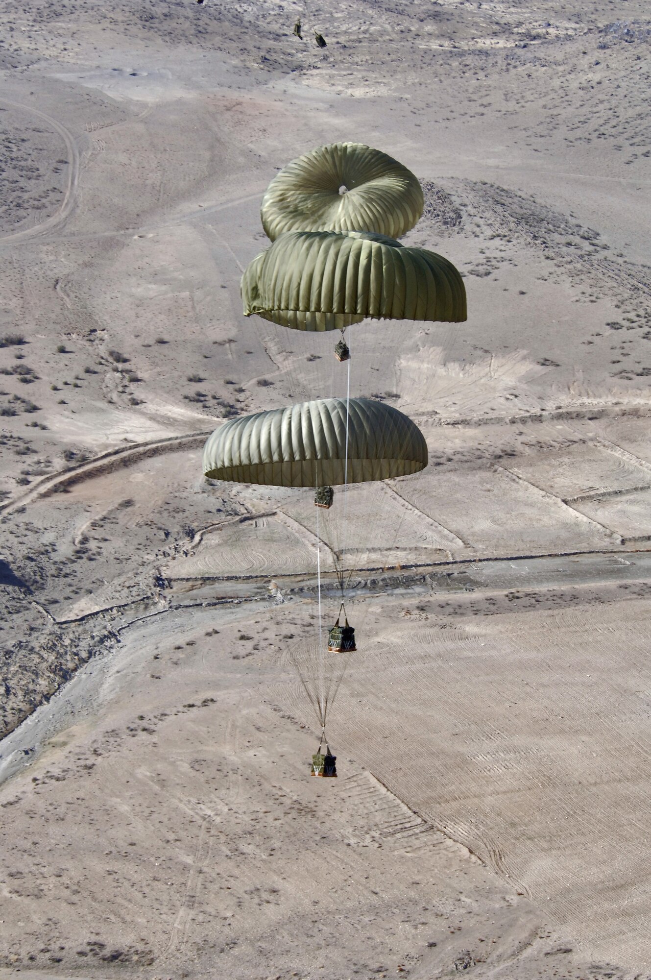 Pallets roll out of a C-130 Hercules near the Pakistan border Thursday, March 9, 2006. The airdrops re-supply forward operating locations surrounded by Afghan mountain ranges.  The aircraft and most of its crew are from the Oklahoma Air National Guard's 185th Airlift Squadron at Will Rogers World Airport, and are deployed to the 774th Expeditionary Airlift Squadron at Bagram Air Base, Afghanistan.  (U.S. Air Force photo/Master Sgt. Lance Cheung)
