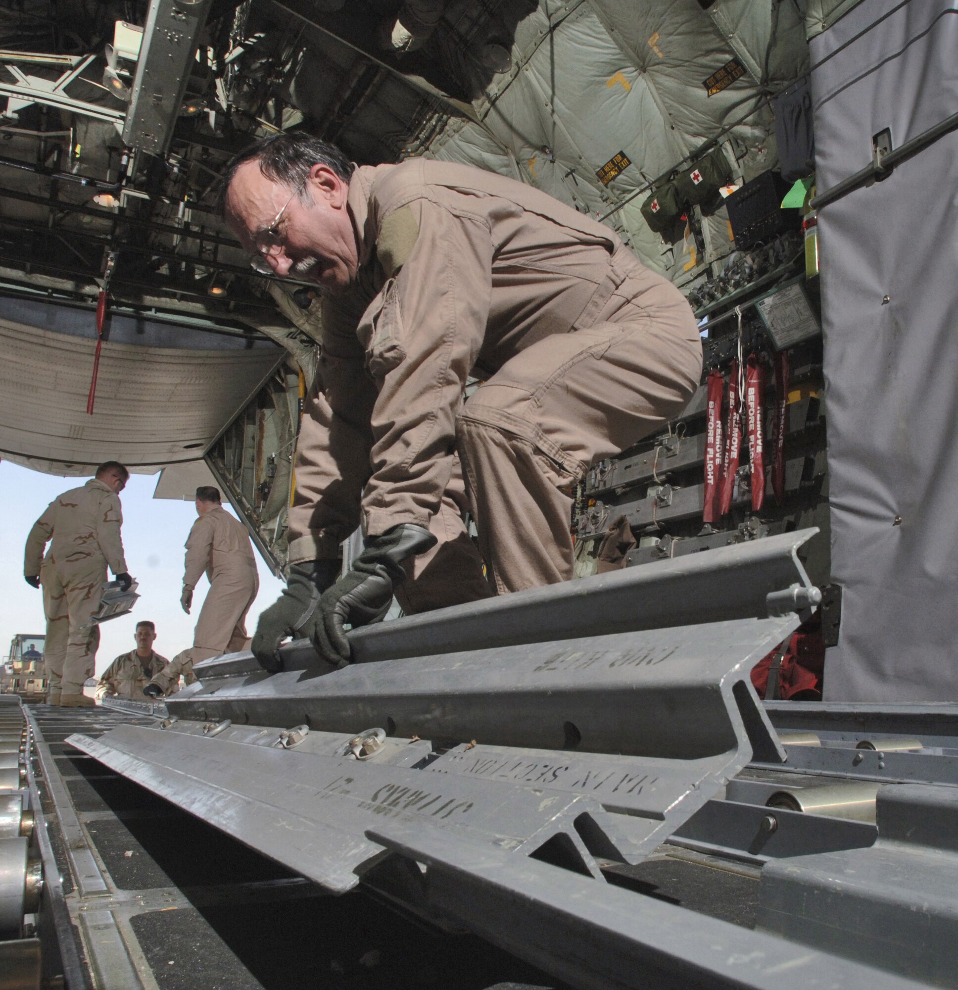 Senior Master Sgt. Ted Poplarchik picks up a restraint rail during reconfiguration inside a C-130 Hercules after an airdrop to forward operating bases near the Pakistan border Thursday, March 9, 2006. Sergeant Poplarchik is with the 144th Airlift Squadron, Kulis Air National Guard Base, Alaska, and deployed to the 774th Expeditionary Airlift Squadron, Bagram Air Base, Afghanistan. (U.S. Air Force photo/Master Sgt. Lance Cheung)