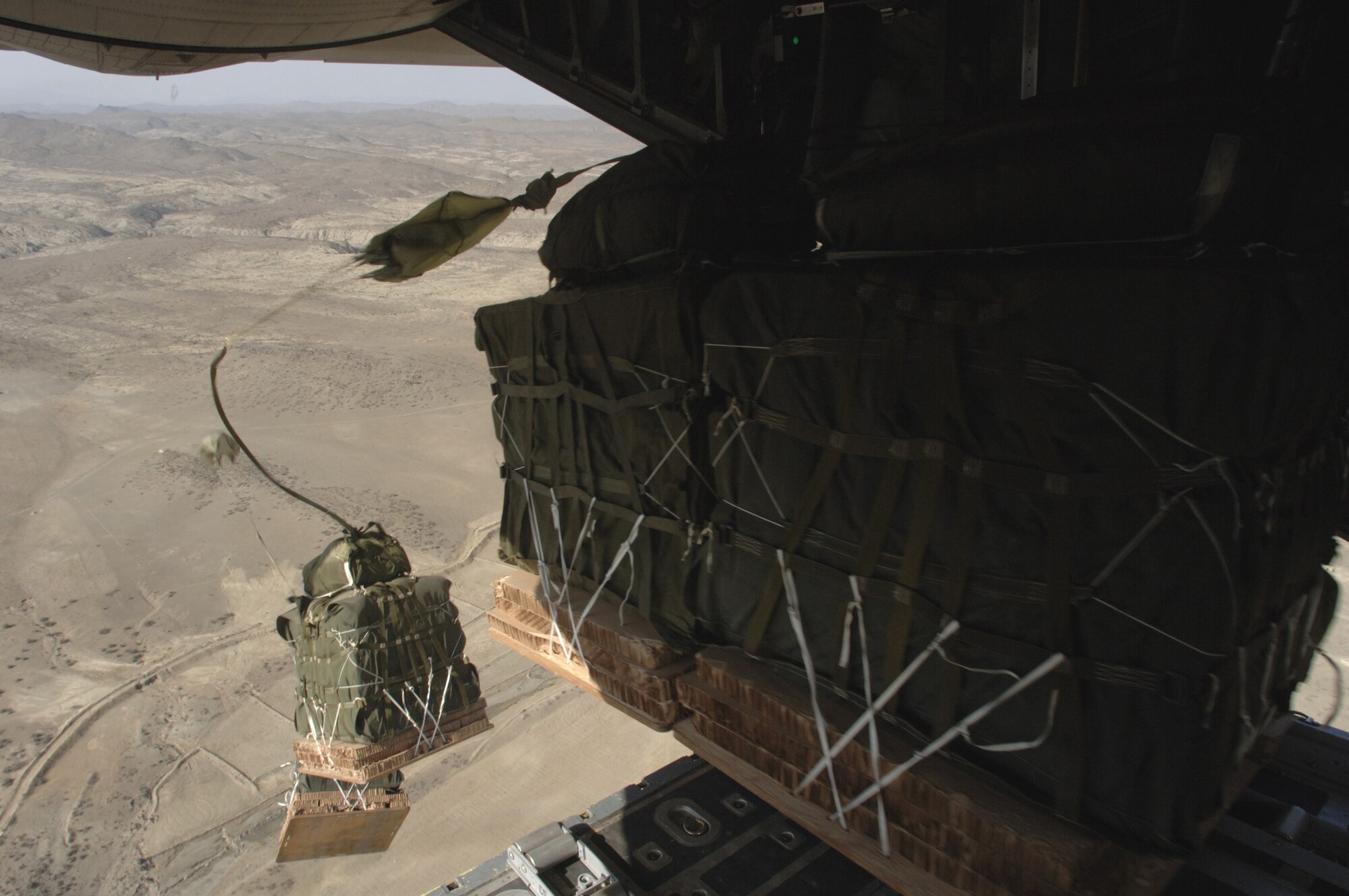 Pallets roll out of a C-130 Hercules near the Pakistan border Thursday, March 9, 2006. The airdrops re-supply forward operating locations surrounded by Afghan mountain ranges.  The aircraft and most of its crew are from the Oklahoma Air National Guard's 185th Airlift Squadron and are deployed to the 774th Expeditionary Airlift Squadron at Bagram Air Base, Afghanistan.  (U.S. Air Force photo/Master Sgt. Lance Cheung)