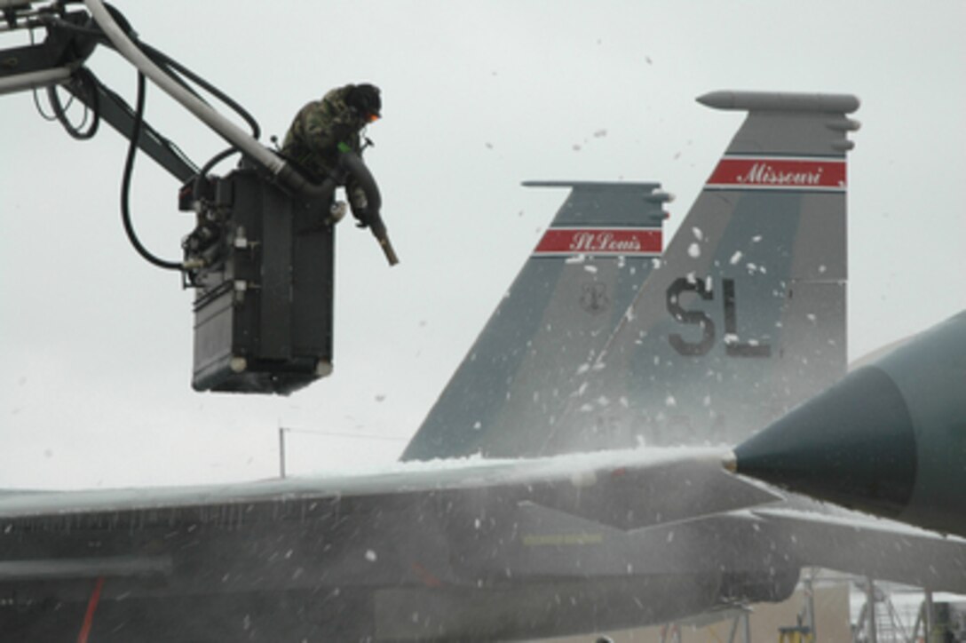 The snow flies as a U.S. Air Force airman de-ices an F-15C Eagle aircraft at Lambert-Saint Louis International Airport in St. Louis, Mo., on March 21, 2006. The Eagle is assigned to the 131st Fighter Wing, Missouri Air National Guard. 