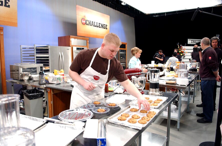 Senior Airman David Sutherland places his cowboy cookies onto plates drizzled with boysenberry sauce to compete against four others during the 2006 Food Network Cookie Challenge Monday, March 20 in Denver.  Airman Sutherland is a missile chef with the 741st Missile Squadron, Minot Air Force Base, N.D. (U.S. Air Force photo/Senior Airman Taylor Marr)