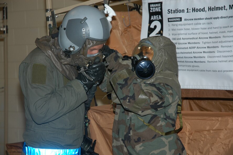 Staff Sgt. Carmina Beedle, at right, life support technician, prepares one of the 353rd Special Operations Group aircrew members for simulated decontamination during a SOLAR ASCENT exercise at Daegu AB, Korea.  (Air Force photo by Master Sgt. Marilyn C. Holliday.)