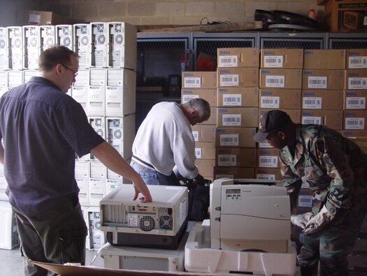 Donald Tyler (left), the director of technology for Center City Consortium in Washington, D.C., assists Staff Sgt. Matthew Marable (center) and Staff Sgt. Bernard Horton (right), of the Air Force Reserve Command's 459th Communications Flight, with preparing computer equipment for transport. The wing donated the used monitors, computers, printers, and a laptop to Saint Thomas More, a consortium school.  The technological equipment is donated to the school through the DoD computers for Learning Program.