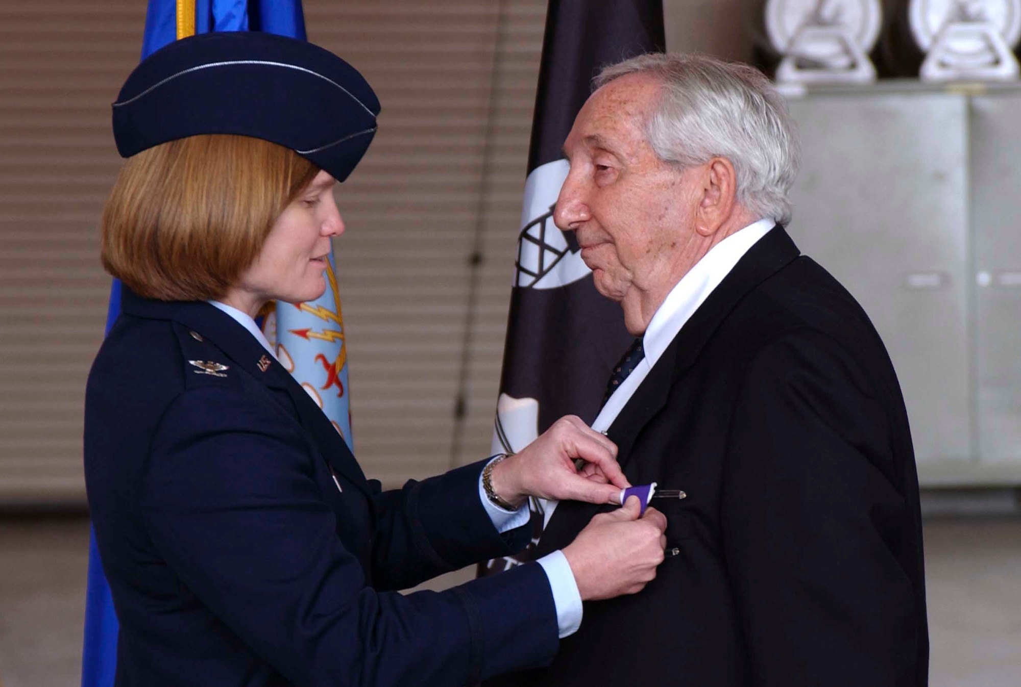 Col. Lyn Sherlock, commander of the 60th Air Mobility Wing, pins the Purple Heart Medal on Mr. Leo Bach.  He received five other medals during the ceremony, including the WWII victory medal and the Prisoner of War Medal. (U.S. Air Force photo by Nan Wylie)


