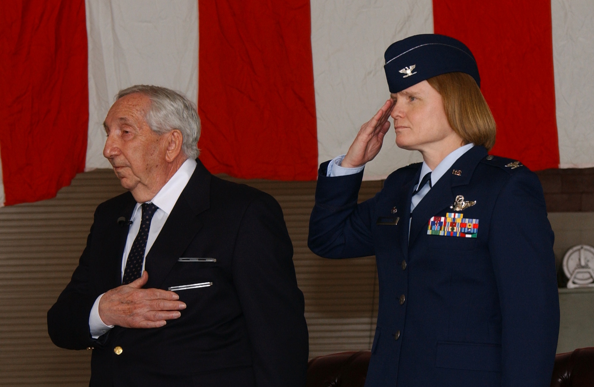 Mr. Leo Bach, a World War II veteran, and Col. Lyn Sherlock, 60th Air Mobility Wing commander, stand during the national anthem. Colonel Sherlock presented Mr. Bach with the Purple Heart during a ceremony here March 21. (U.S. Air Force photo by Nan Wylie)


