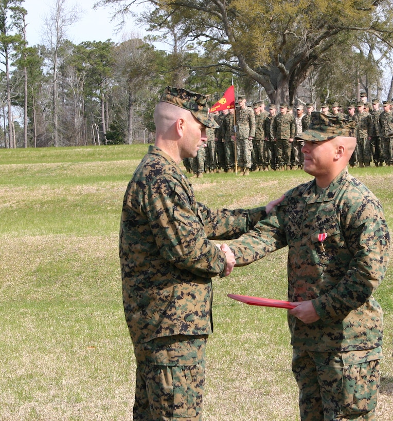 Gunnery Sgt. David L. Sutherland shakes hands with Lt. Col. Michael M. Sweeney, Commanding Officer, 8th Communication Battalion, II Marine Expeditionary Force, during a Bronze Star ceremony March 23. Sutherland was awarded a Bronze star for  leading his Marines in more than 85 convoy security missions, covering the entire Al-Anbar Province, Iraq, resulting in the safe transportation of millions of dollars worth of vital communication assets, tactical rolling stock and escorted vehicles without major incident or injury.