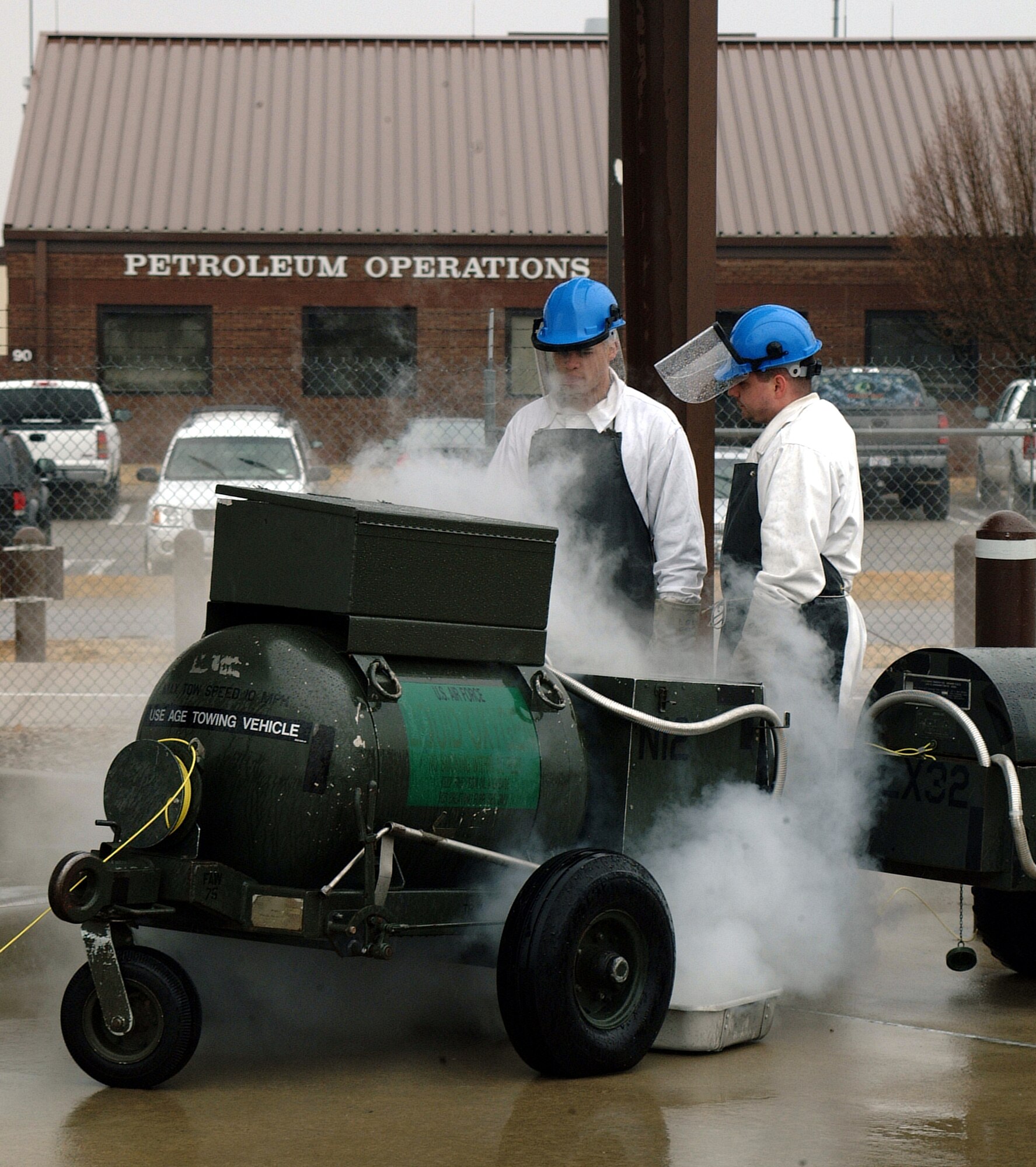 Airman 1st Class Josue Santiago, with the Air Force Reserve's 442nd Logistics Readiness Squadron, is trained by Staff Sgt. Mathew Sutton, 509th Bomb Wing, on refilling a liquid oxygen cart at the LOX storage facility at Whiteman Air Force Base, Mo.  The 442nd LRS supports A-10s from the 442nd Fighter Wing.  (Photo By Master Sgt. Bill Huntington)  