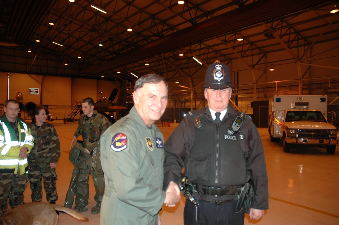 Police Constable Paul Glover, Ministry of Defence police, shakes hands with Gen. Tom Hobbins, U.S. Air Forces in Europe commander, during his visit Feb. 16 to RAF Lakenheath.