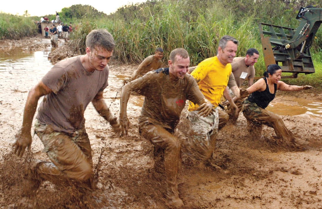 Runners dash through one of the several mud pits on the 4.5-mile course during the 12th Annual CSSG-3 Swamp Romp here. The race was not exclusively military; civilians teams froom around Hawaii also participated in the event.