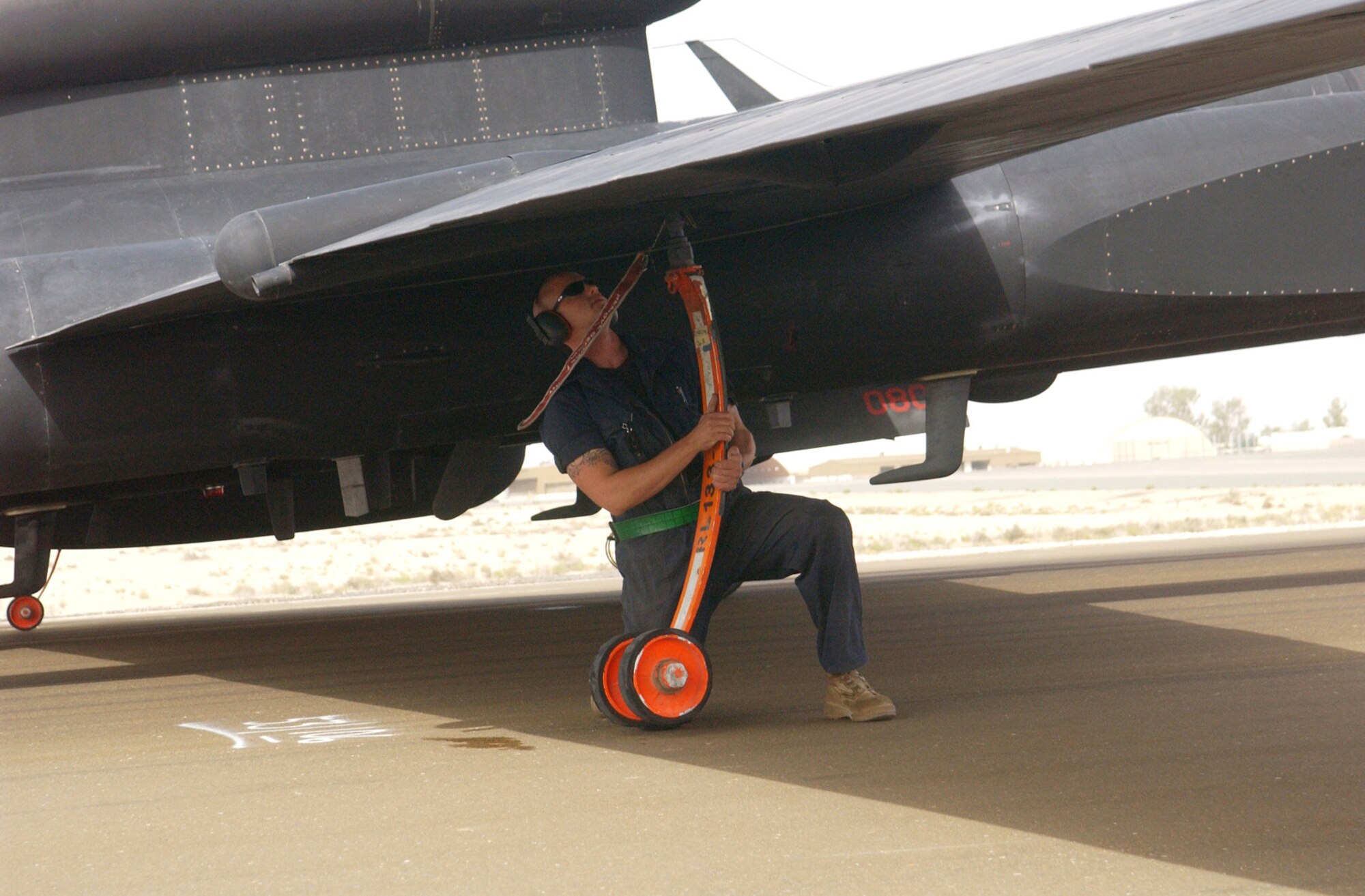 Senior Airman Jordan Mihm installs a pogo wheel onto the wing of a U-2 "Dragon Lady" that landed at a forward-deployed location. The wheels support the plane's long wings as it taxis. Airman Mihm is assigned to the 380th Expeditionary Aircraft Maintenance Squadron and is deployed from Beale Air Force Base, Calif. (U.S. Air Force photo/Tech. Sgt. Andrew Leonhard)   