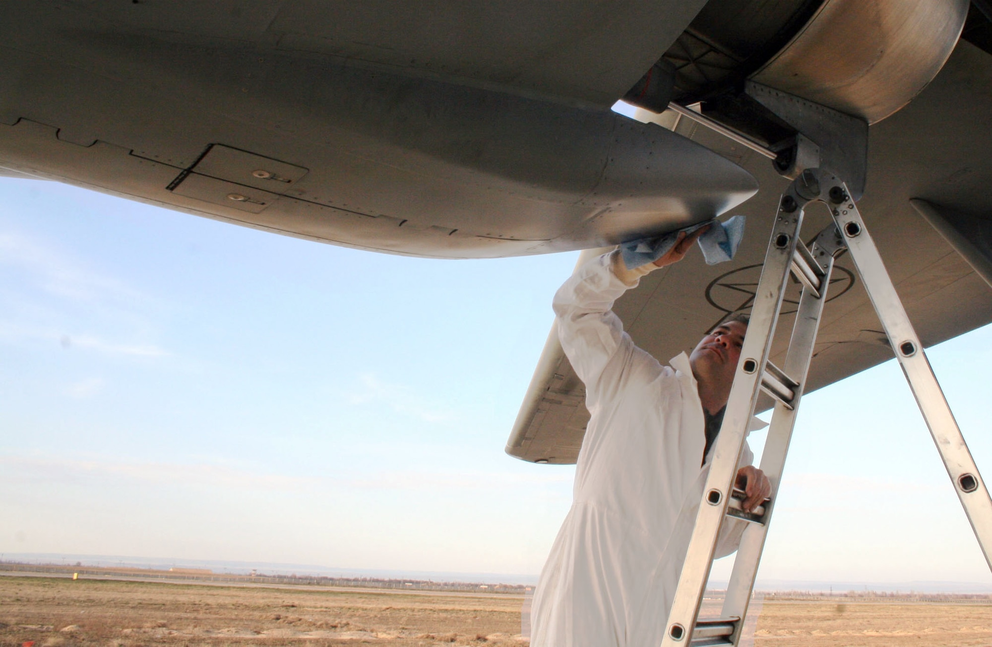 Tech. Sgt. Dean DeFrank wipes down an engine after routine servicing at Manas Air Base, Kyrgyzstan, Saturday, March 25, 2006.  Sergeant DeFrank is a C-17 engine specialist with the 376th Air Expeditionary Wing Aircraft Maintenance Squadron, but like everyone in his flight, when his part of the job is done he does whatever is required to keep the aircraft at a high standard of maintenance. (U.S. Air Force photo/Staff Sgt. Lara Gale)