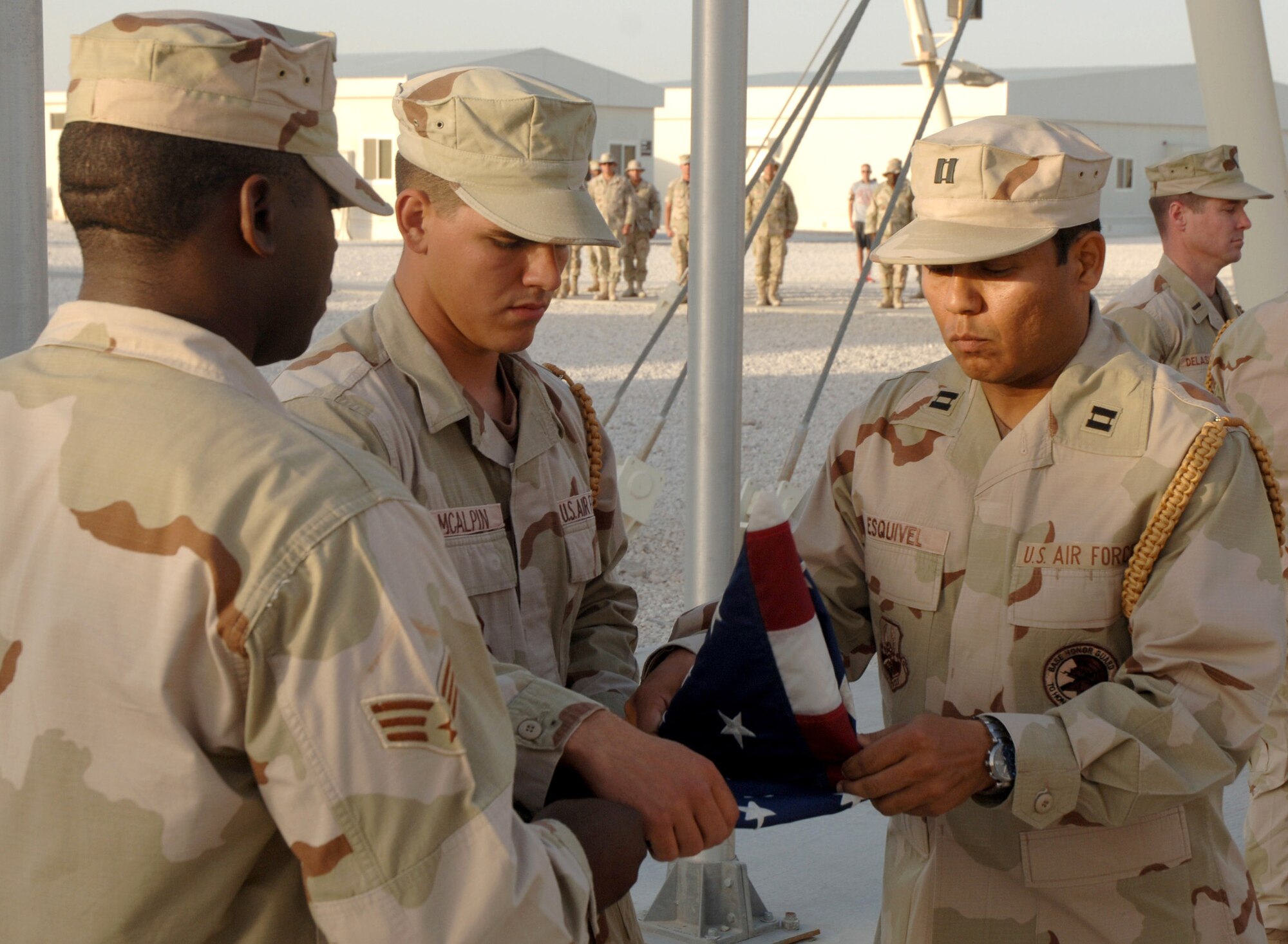 Members of the base honor guard fold the American flag during a retreat ceremony at a deployed location in Southwest Asia Friday, March 24, 2006. The honor guard provides honors and ceremonies for distinguished personnel, and posts the colors for change of command ceremonies, promotion ceremonies, parades and celebrations. They also render military funeral honors for active duty members who served honorably in the Air Force.  (U.S. Air Force photo/Staff Sgt. Joshua Strang)
