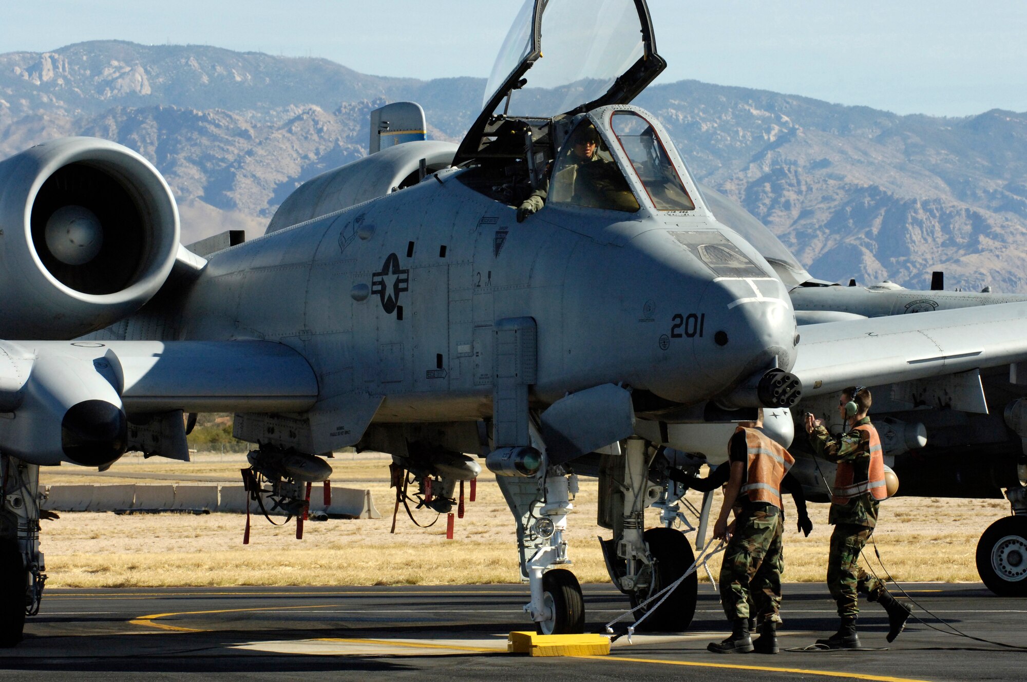 An A-10 Thunderbolt II sits on the end of the runway as maintainers perform pre-flight inspections at Davis-Monthan Air Force Base, Ariz., Thursday, March 23, 2006, as part of the 2006 Hawgsmoke competition. This year marks the 30th anniversary of the "Warthog." Hawgsmoke is a biennial bombing and tactical gunnery competition of the A-10, in which 20 squadrons around the globe come together to compete for the honor of the "best of the best" in ground attack and target destruction. (U.S. Air Force photo by/Airman 1st Class Jesse Shipps)
 
