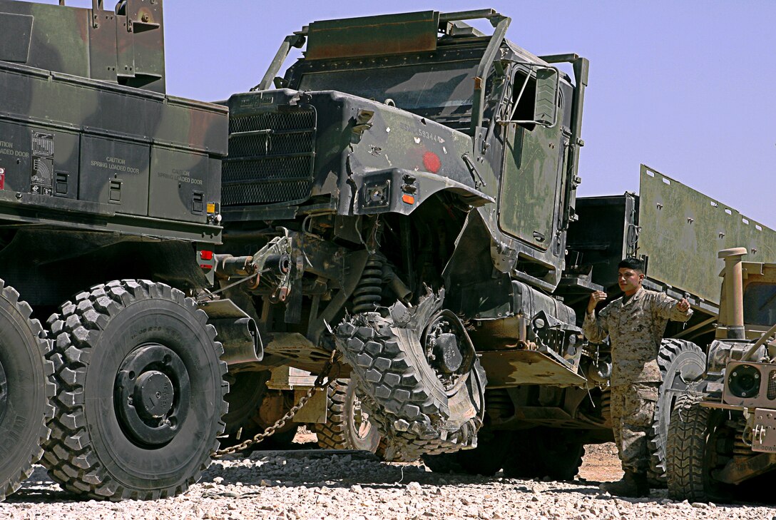 Motor Transport Maintenance Platoon's Wrecker Marines recover vehicles that break down or are damaged in attacks against American forces operating in the northwest region of Iraq. Corporal Hector F. Deleon guides a fellow wrecker operator as they park a damaged seven-ton truck March 27, 2006. The MTM Platoon Marines work long hours to support convoys and patrols by their parent command, Combat Logistics Battalion 7, and other units working in northwest Iraq.